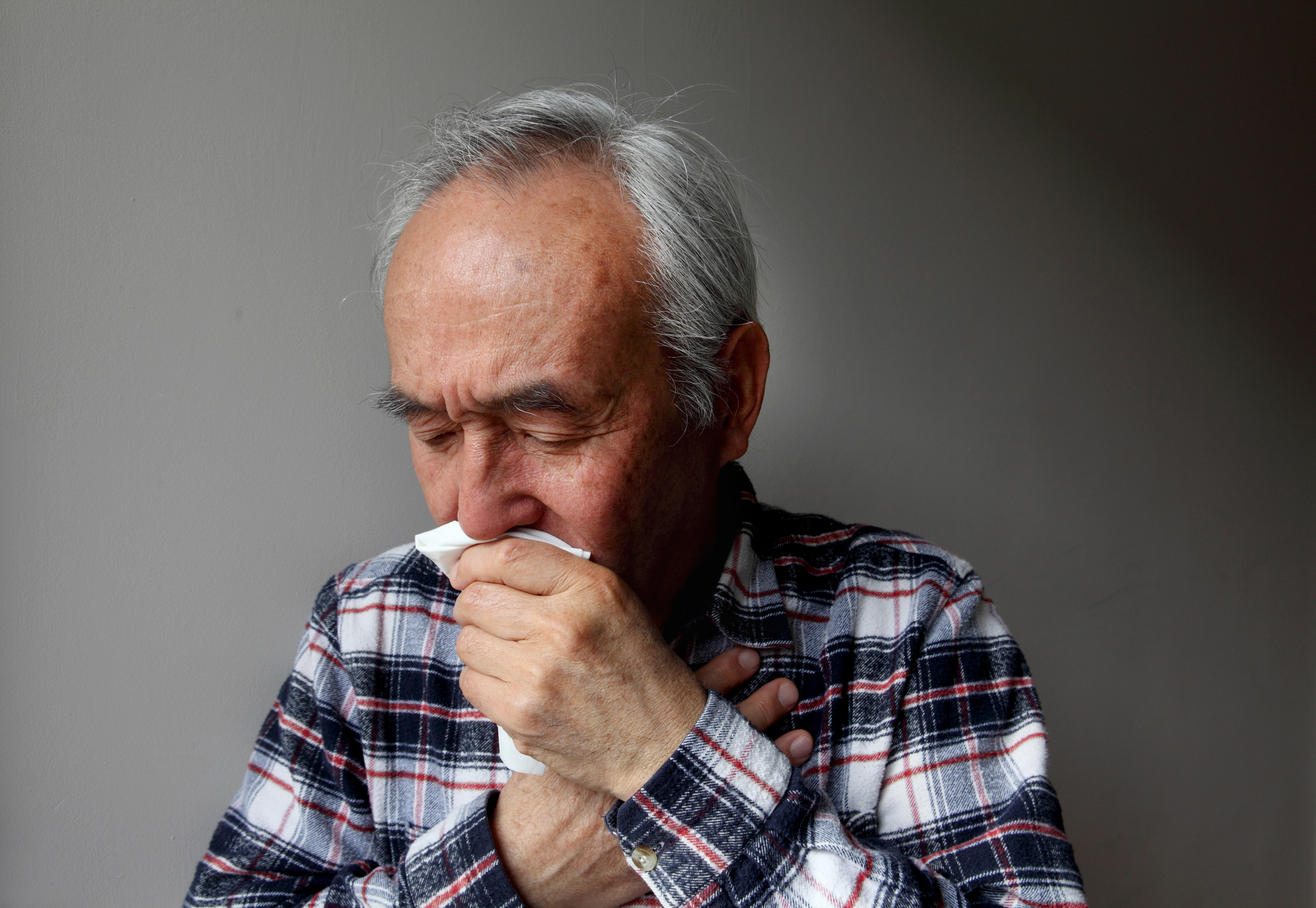 Señor tosiendo en una servilleta | Foto: Getty Images