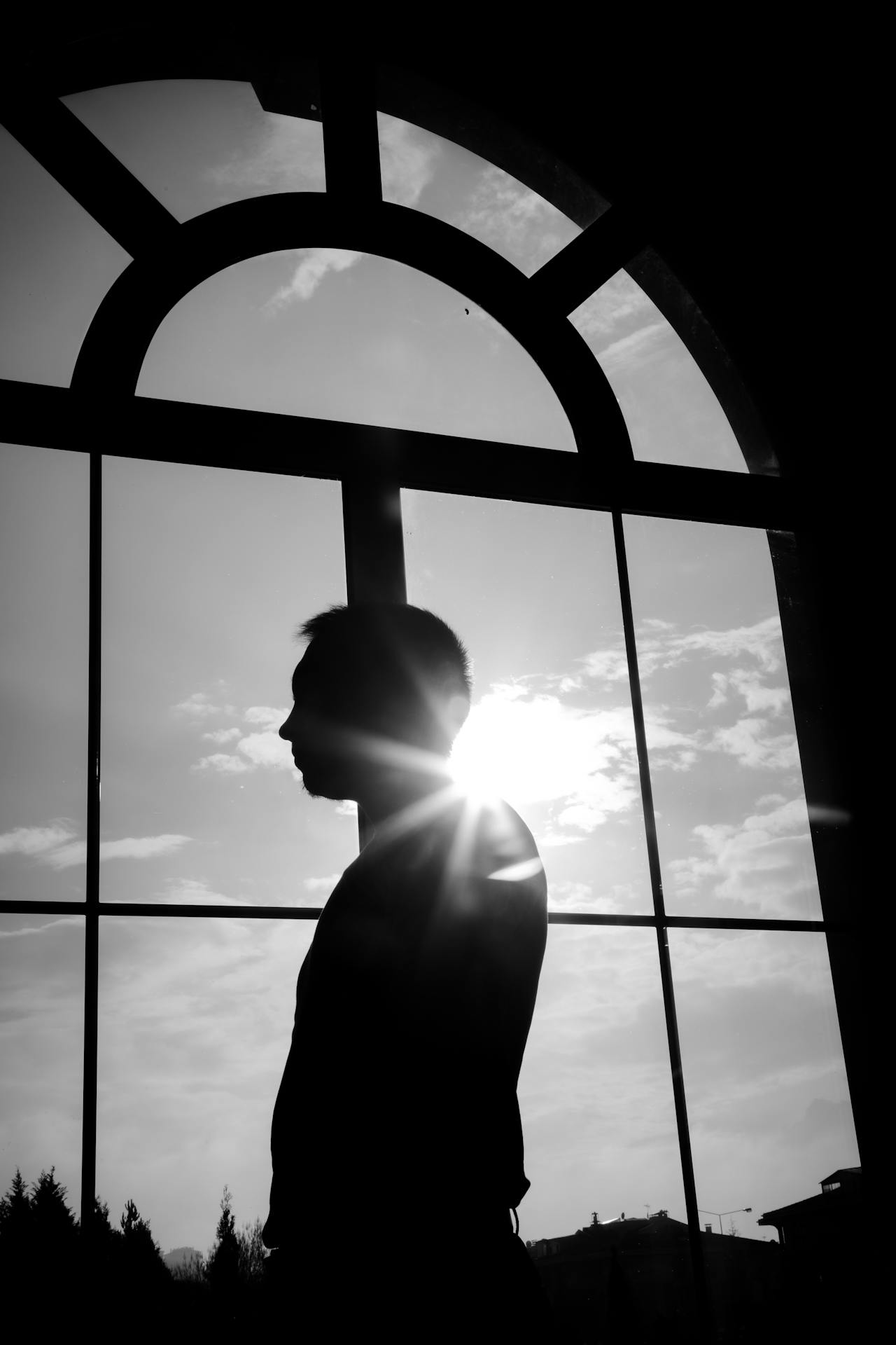 Un hombre de pie cerca de una ventana arqueada | Fuente: Pexels
