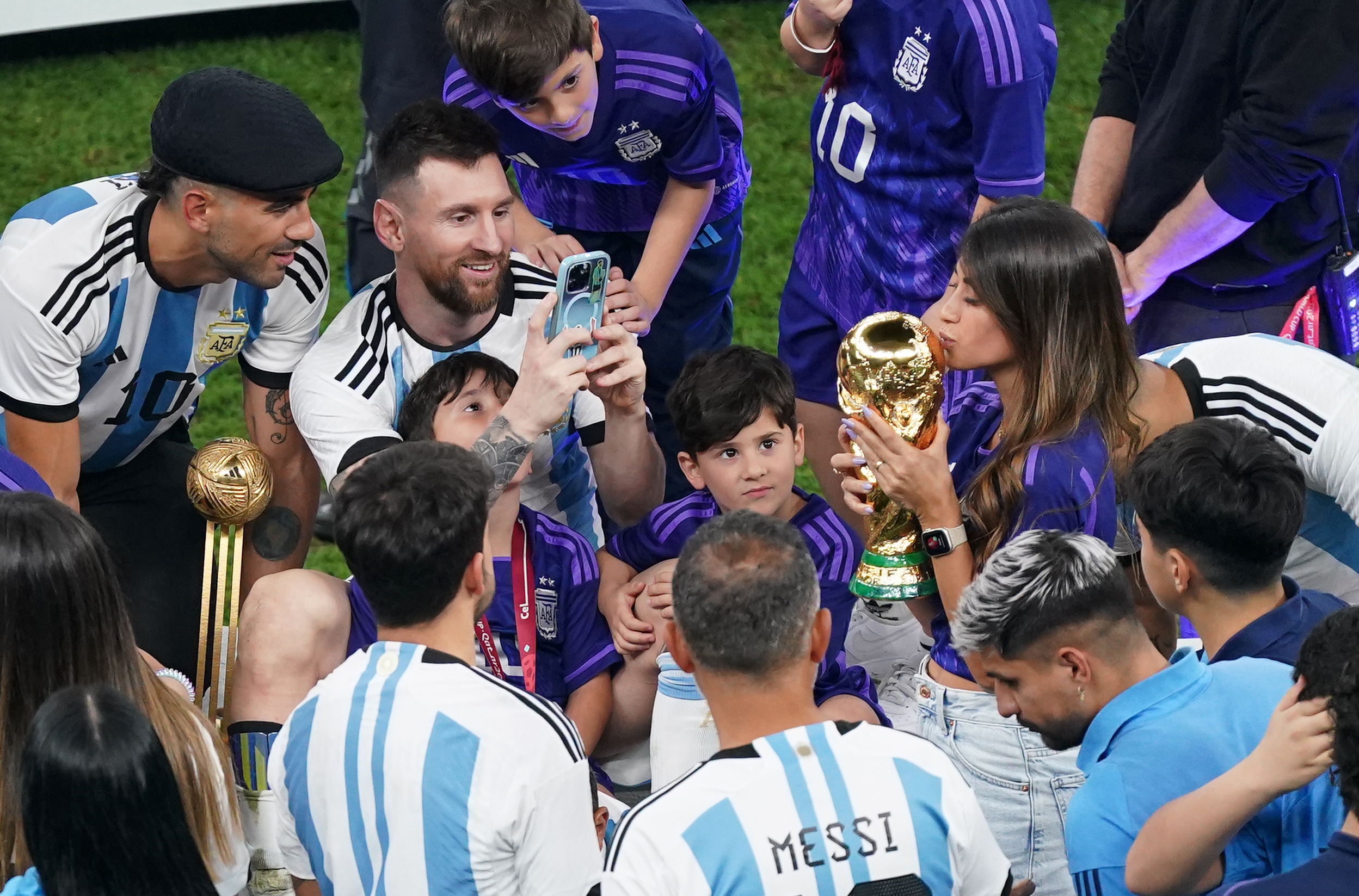 Lionel Messi toma una foto de su esposa, Antonela Roccuzzo besando el trofeo de la Copa del Mundo después de la final de la Copa Mundial de la FIFA en el Estadio Lusail, Qatar. | Fuente: Getty Images