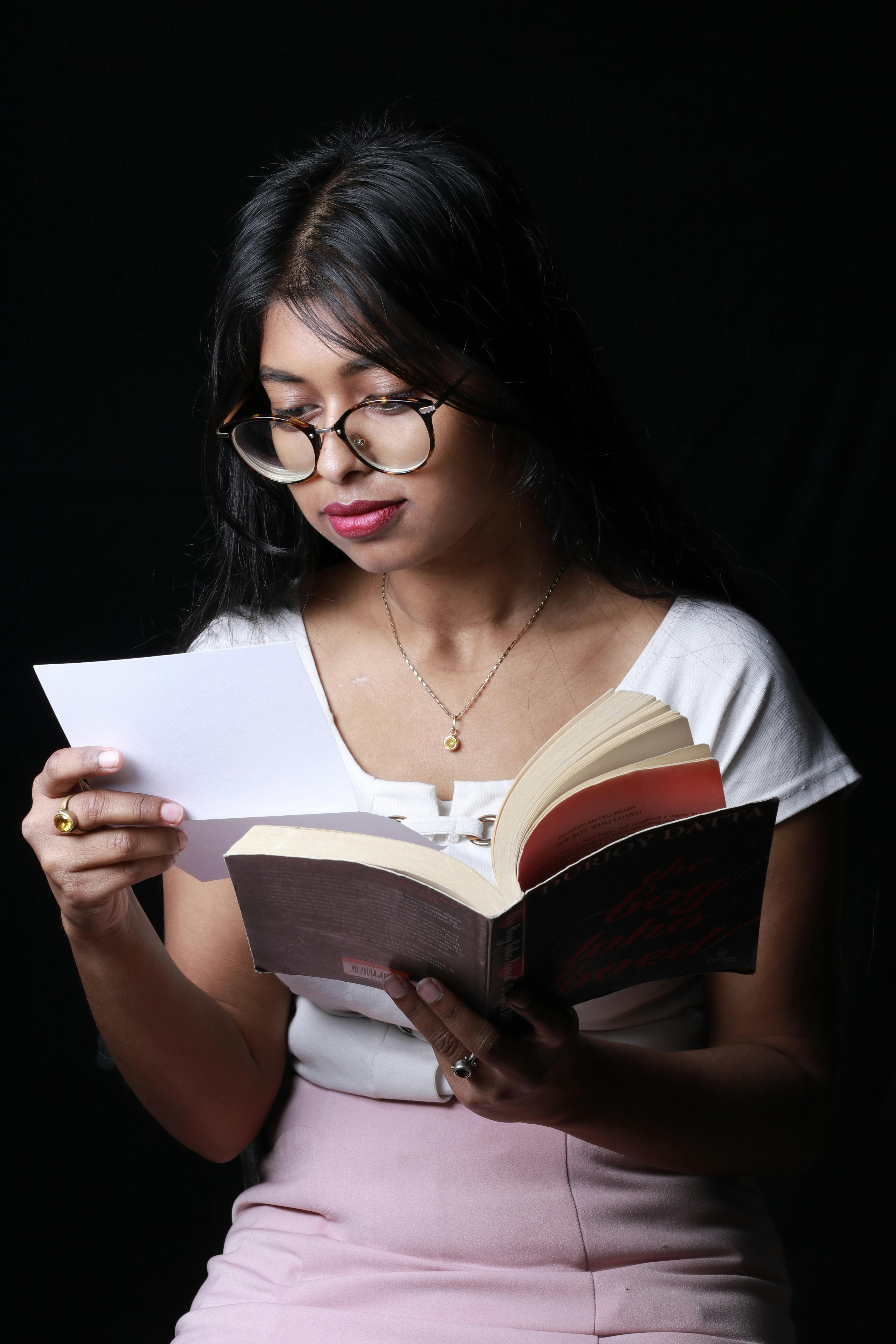 Una niña leyendo una carta mientras sostiene un libro | Foto: Pexels
