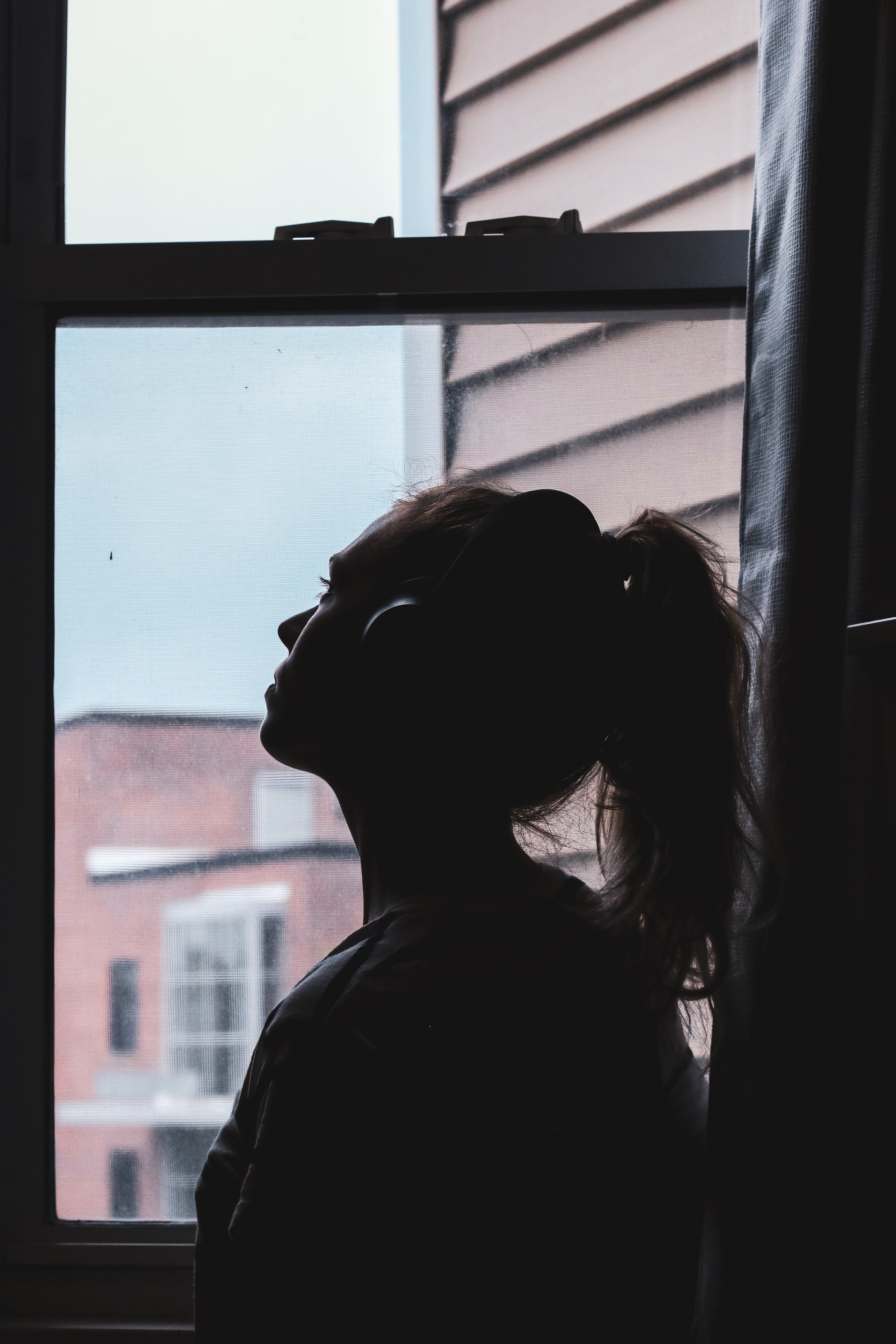 Mujer mira por la ventana. | Foto: Pexels