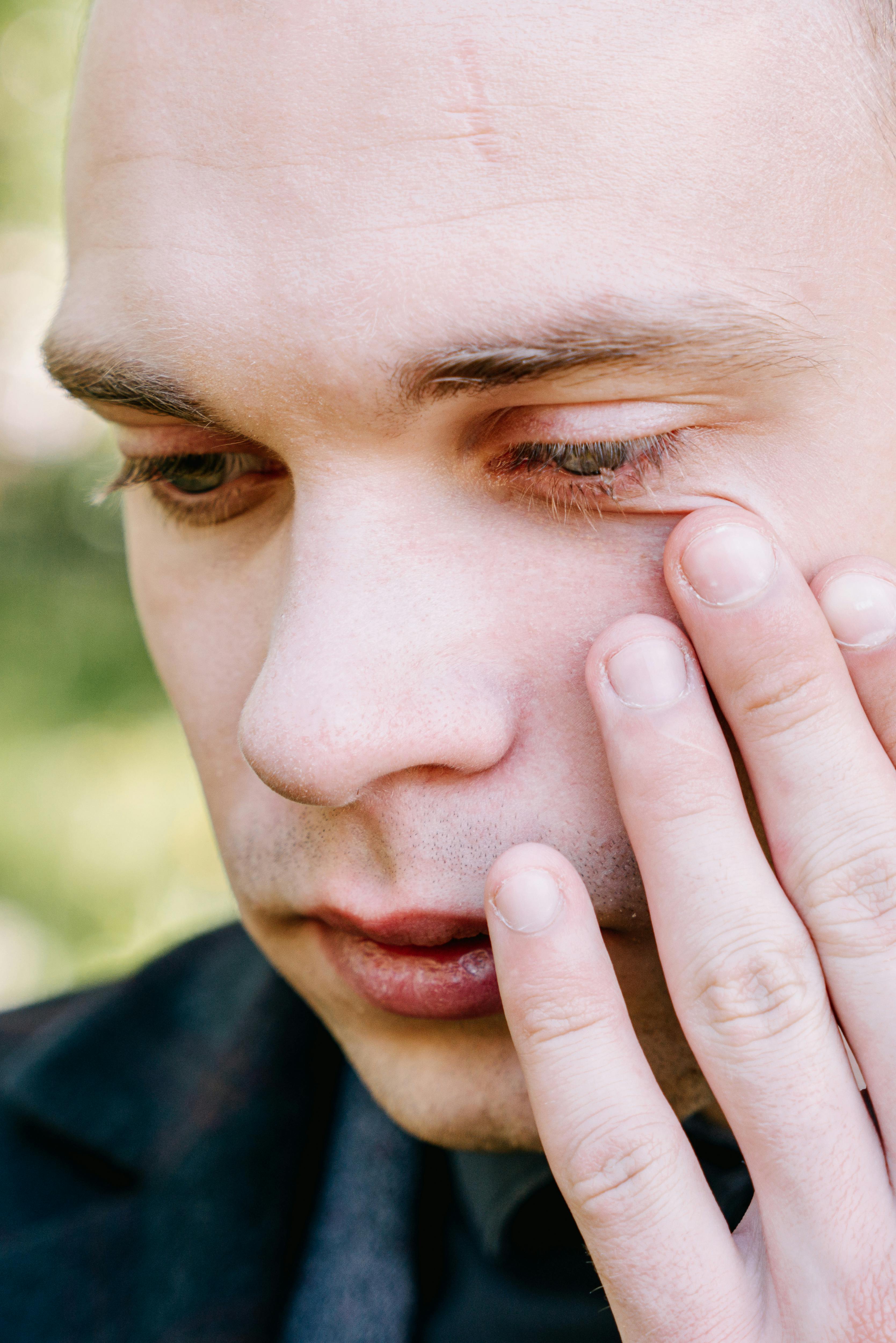 Un hombre secándose las lágrimas | Fuente: Pexels