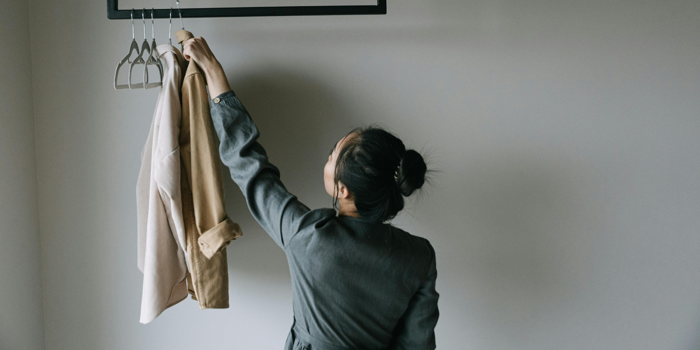 Una mujer colgando ropa | Fuente: Pexels