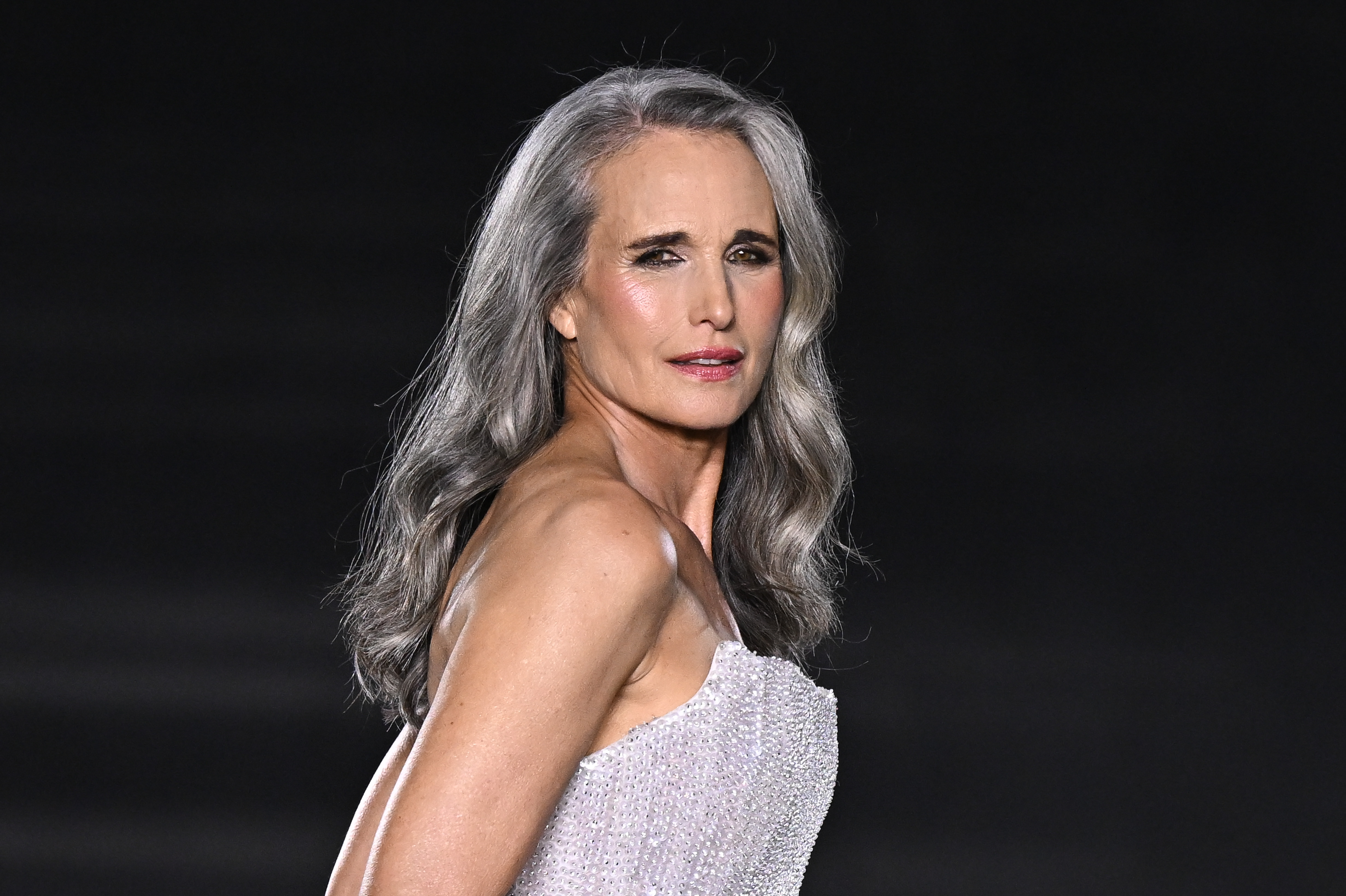 MacDowell luce su larga melena plateada con ondas sueltas en el desfile de L'Oréal Paris de septiembre de 2024. Su pelo se había vuelto notablemente más canoso desde su aparición en Cannes en 2022, lo que demuestra cómo su color natural siguió cambiando con el paso del tiempo. | Fuente: Getty Images