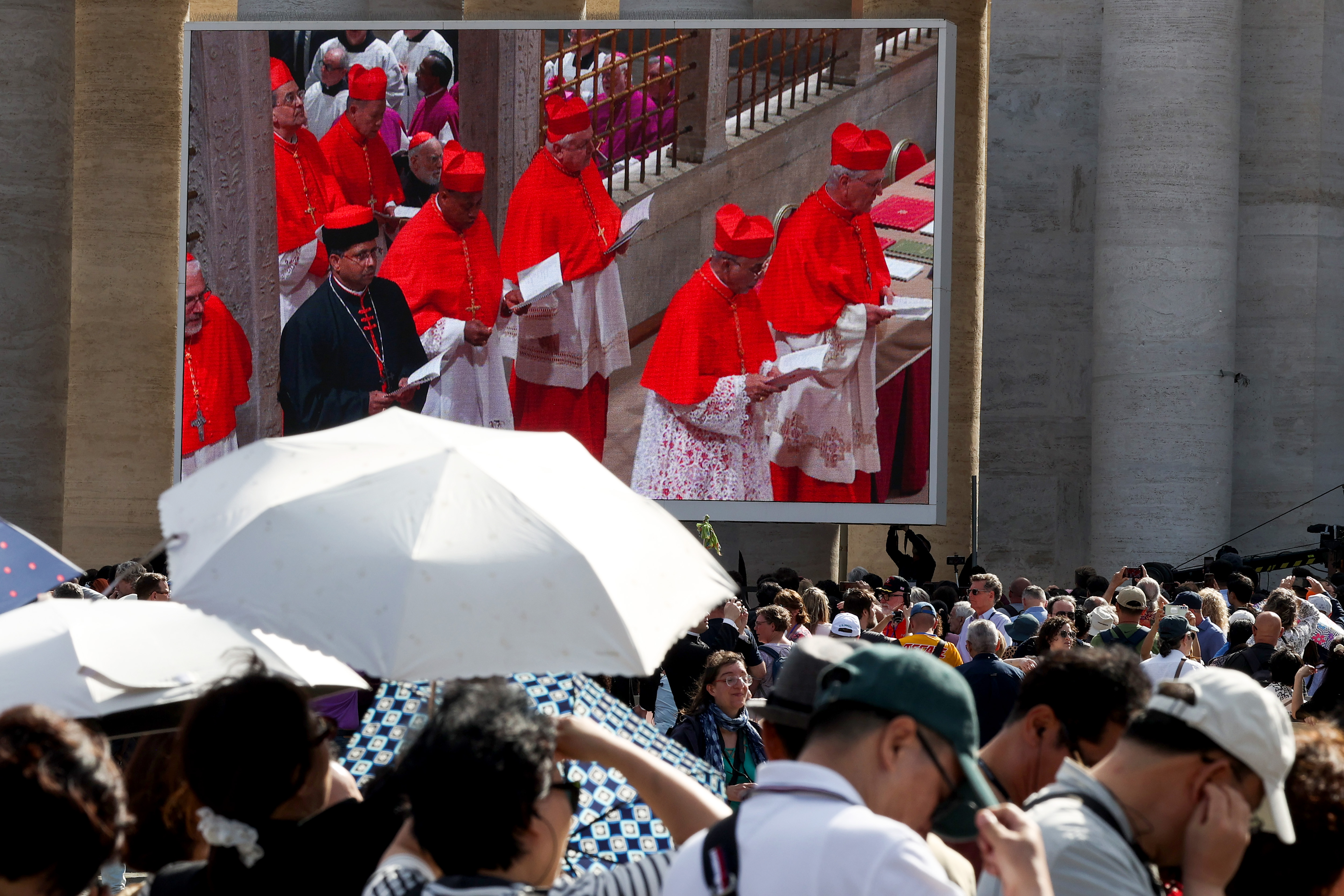 Cardenales entran en la Capilla Sixtina para el cónclave, mostrado en pantallas en la Plaza de San Pedro en la Ciudad del Vaticano el 7 de mayo de 2025 | Fuente: Getty Images