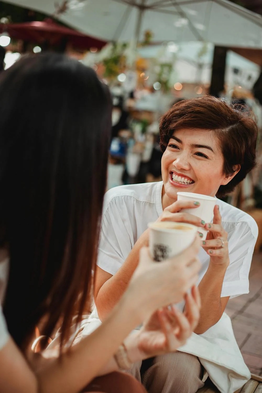 Una mujer sonriendo a su amiga en una cafetería | Fuente: Pexels