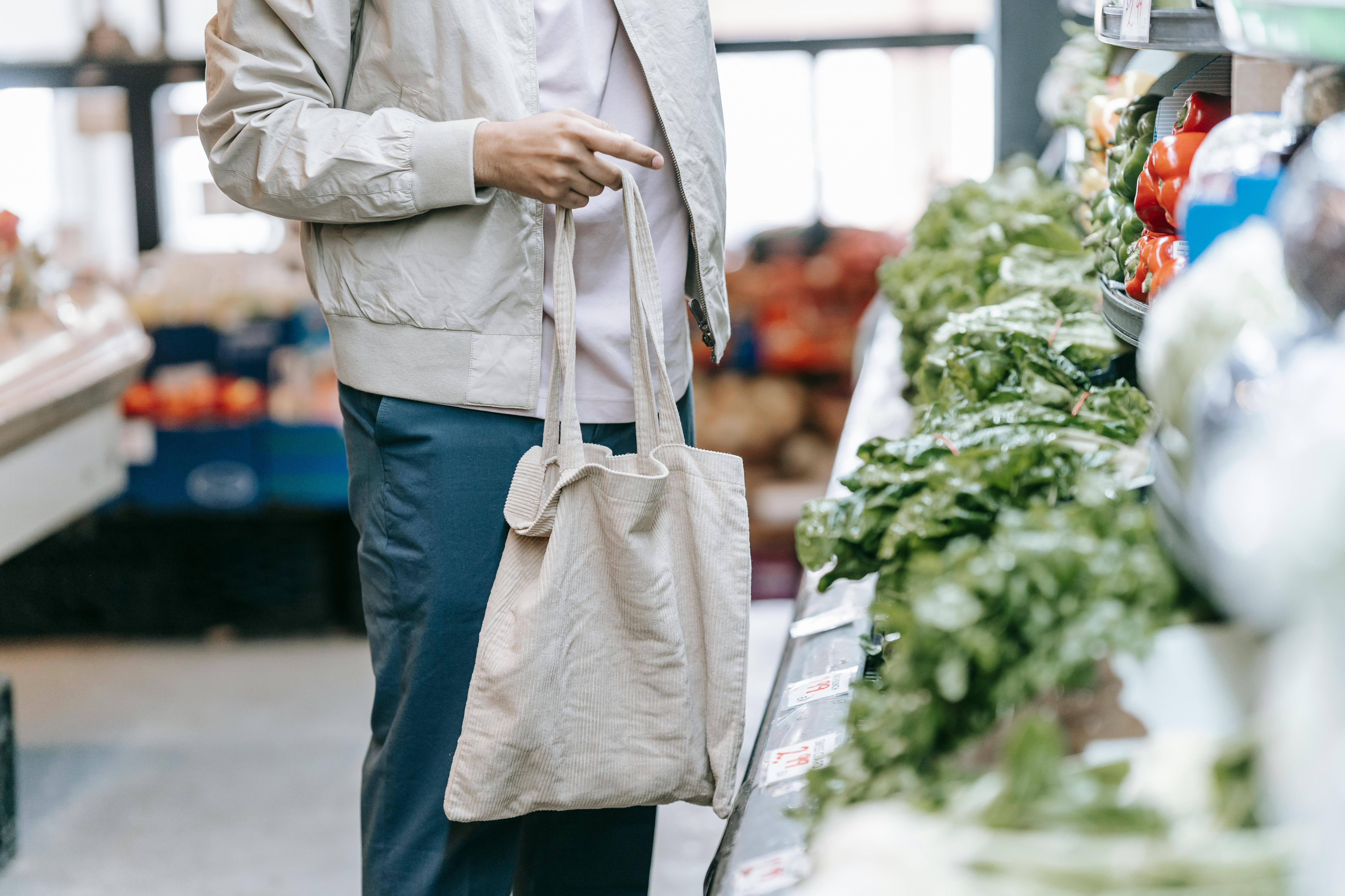 Un hombre con la compra en la espalda en un supermercado | Fuente: Pexels