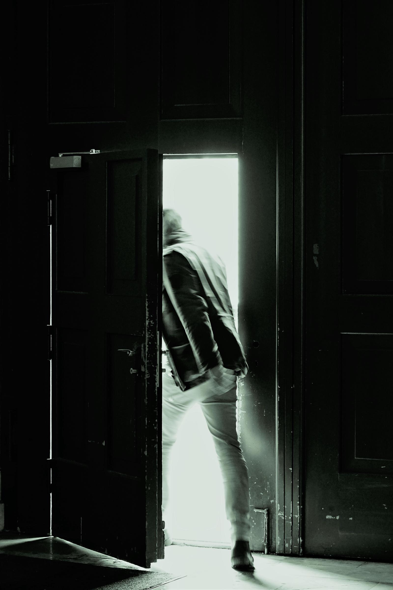Un hombre sale corriendo por una puerta | Fuente: Freepik