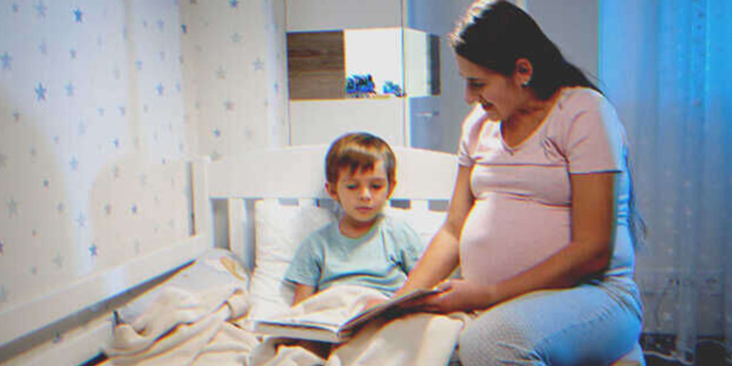 Una mujer embarazada leyendo un libro a un niño | Foto: Shutterstock