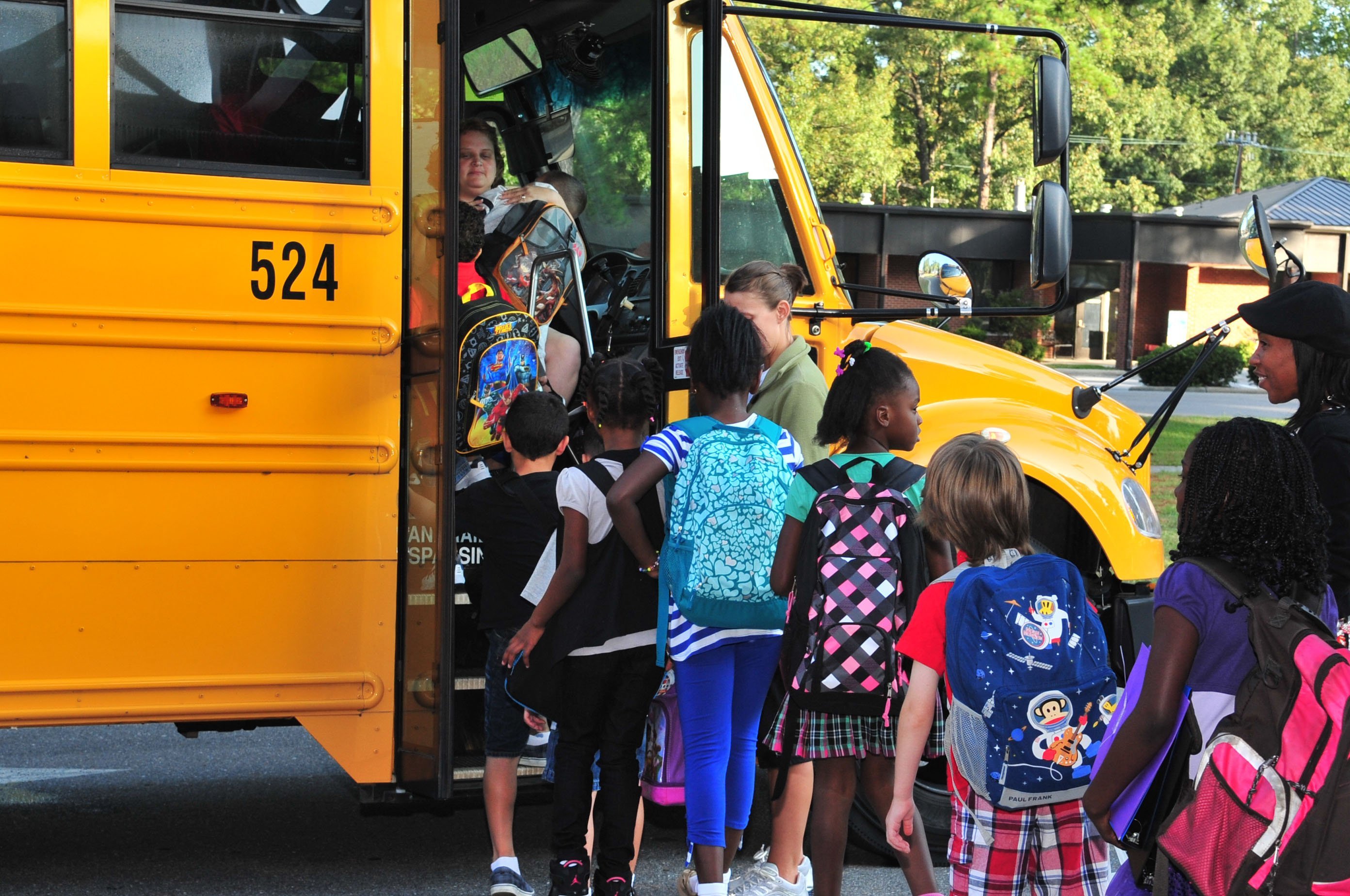 Niños suben al autobús escolar. || Fuente: US Air Force