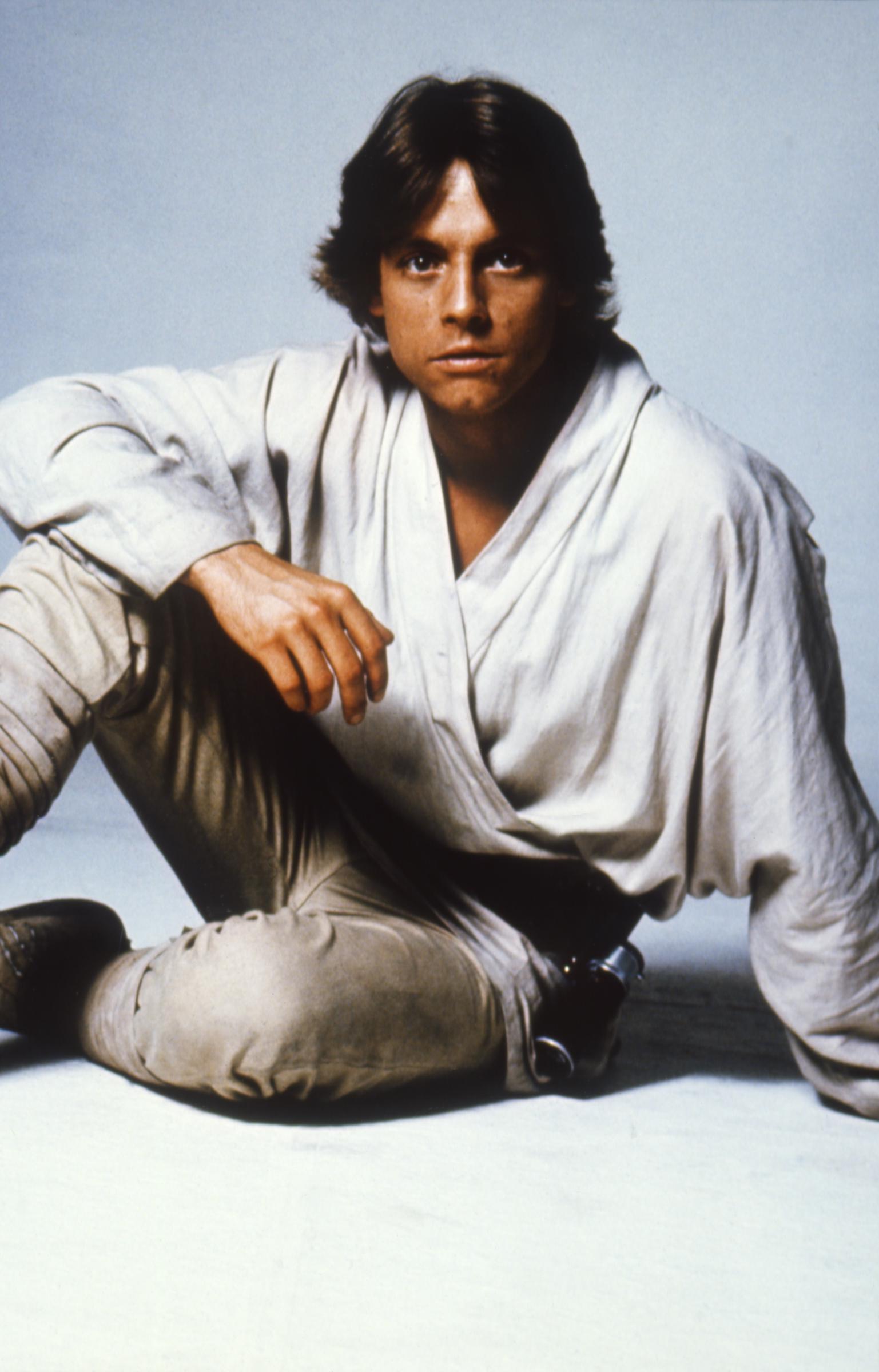 El actor posó caracterizado para "Star Wars: A New Hope", vistiendo el traje sencillo y de color claro que se convirtió en sinónimo de la presentación del joven héroe. El retrato capturó su apariencia antes del accidente automovilístico del 11 de enero de 1977, que le fracturó la nariz y el pómulo izquierdo. Para cuando la película se estrenó el 25 de mayo de 1977, su actuación había impulsado al actor, anteriormente poco conocido, a la fama internacional. | Fuente: Getty Images