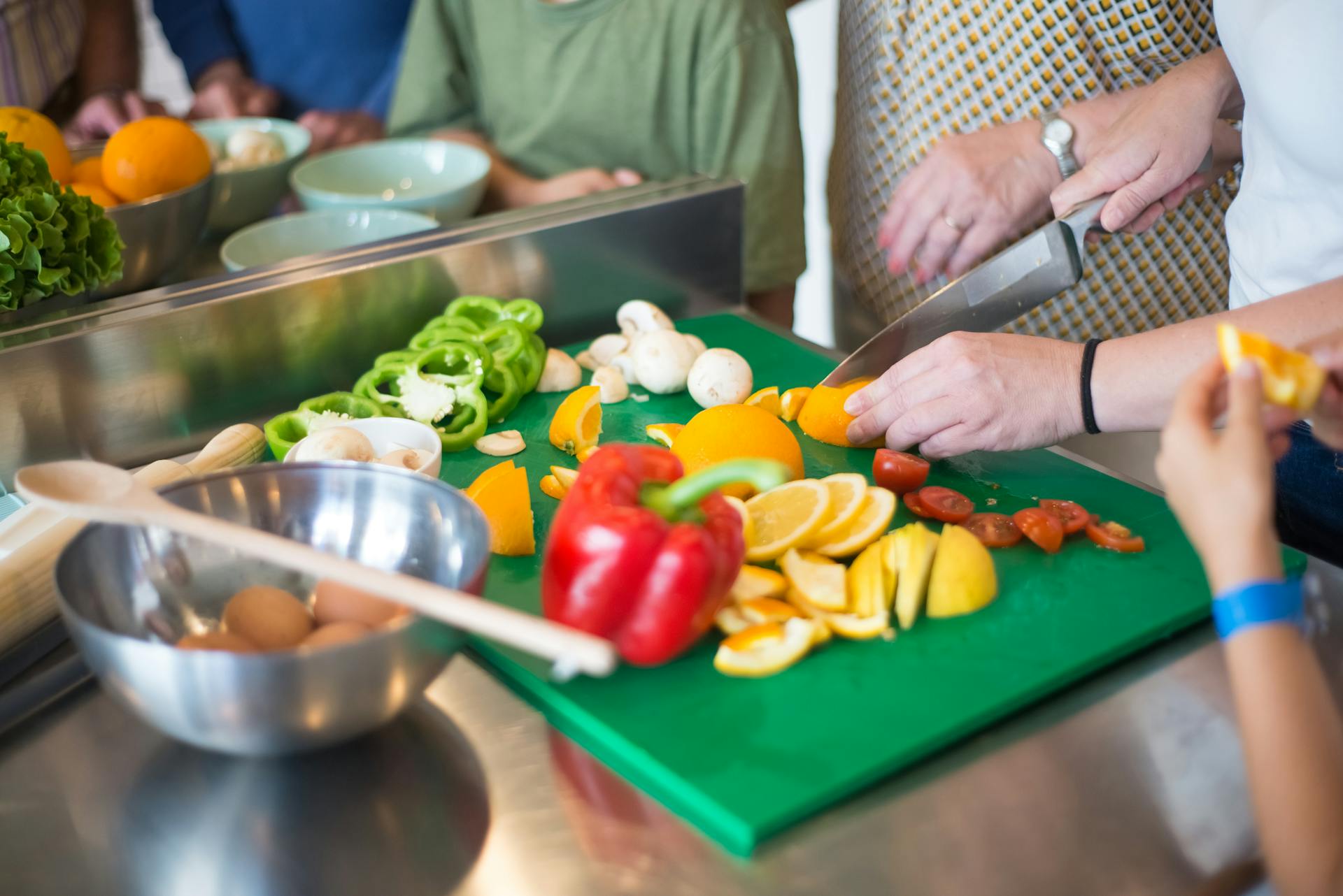 Primer plano de los miembros de una familia preparando la comida en la cocina | Fuente: Pexels