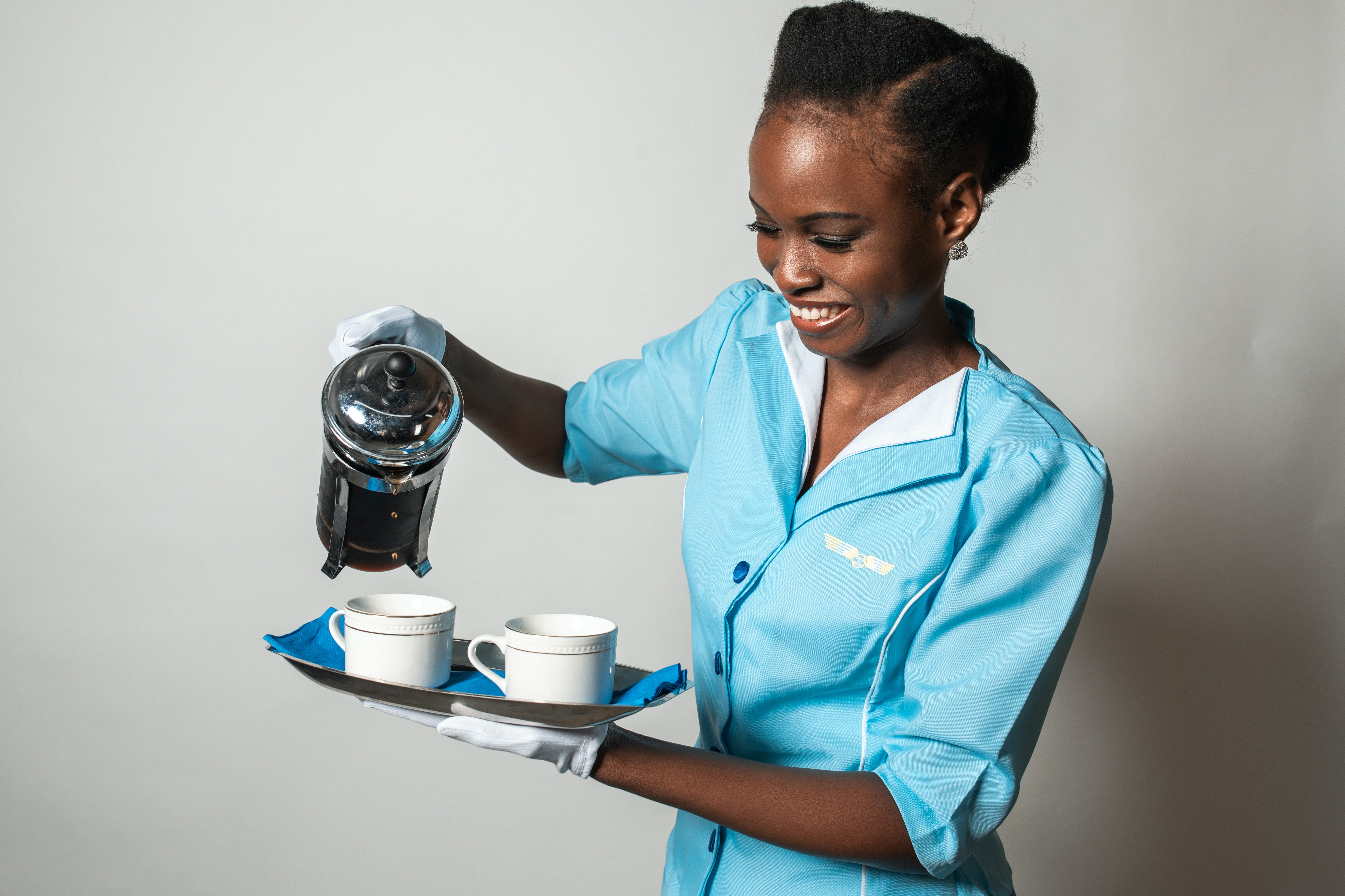 Azafata de vuelo sirviendo café | Foto: Pexels