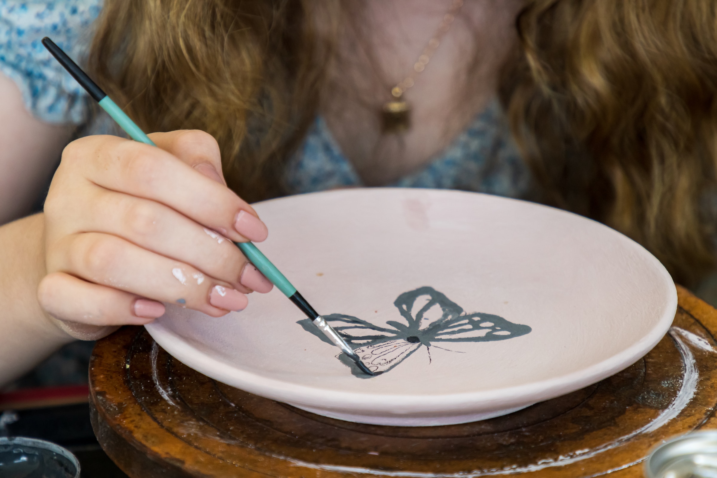 Una persona pintando en un plato de cerámica | Fuente: Unsplash