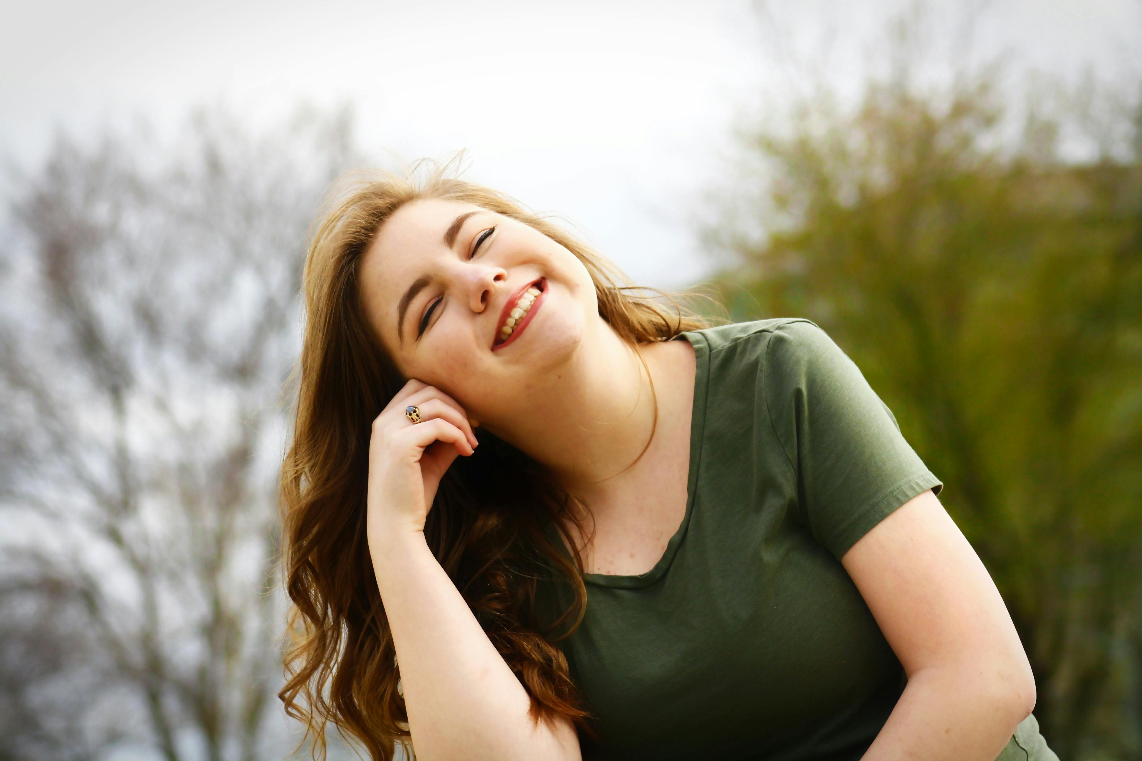 Una mujer feliz sonriendo mientras disfruta del sol | Fuente: Pexels