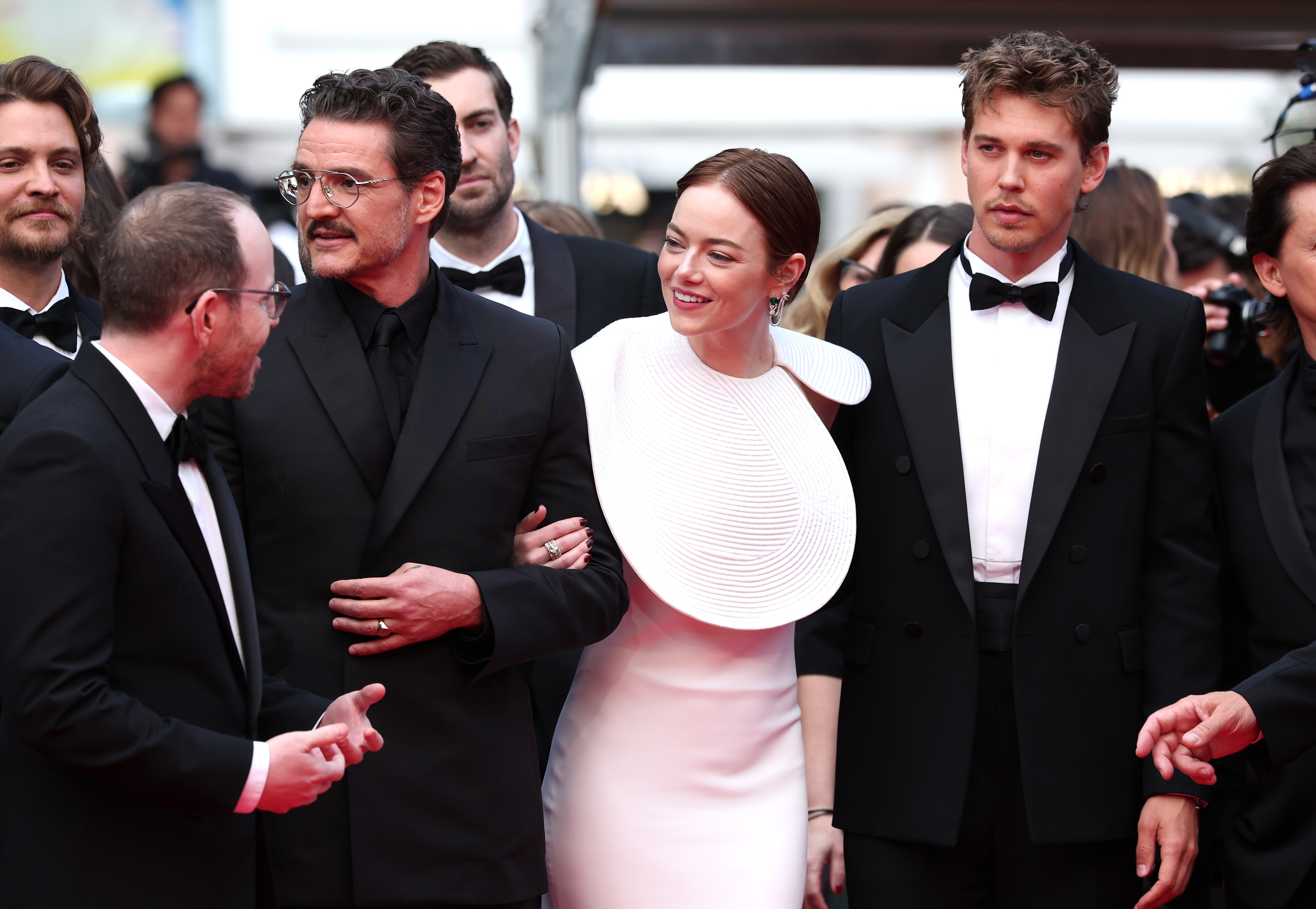 El elenco de "Eddington" comparte un momento divertido antes de entrar a la proyección. Emma Stone camina del brazo con Pedro Pascal, mientras Austin Butler los observa. Sus conjuntos coordinados en blanco y negro aportan un toque de elegancia refinada al estilo de la alfombra roja.