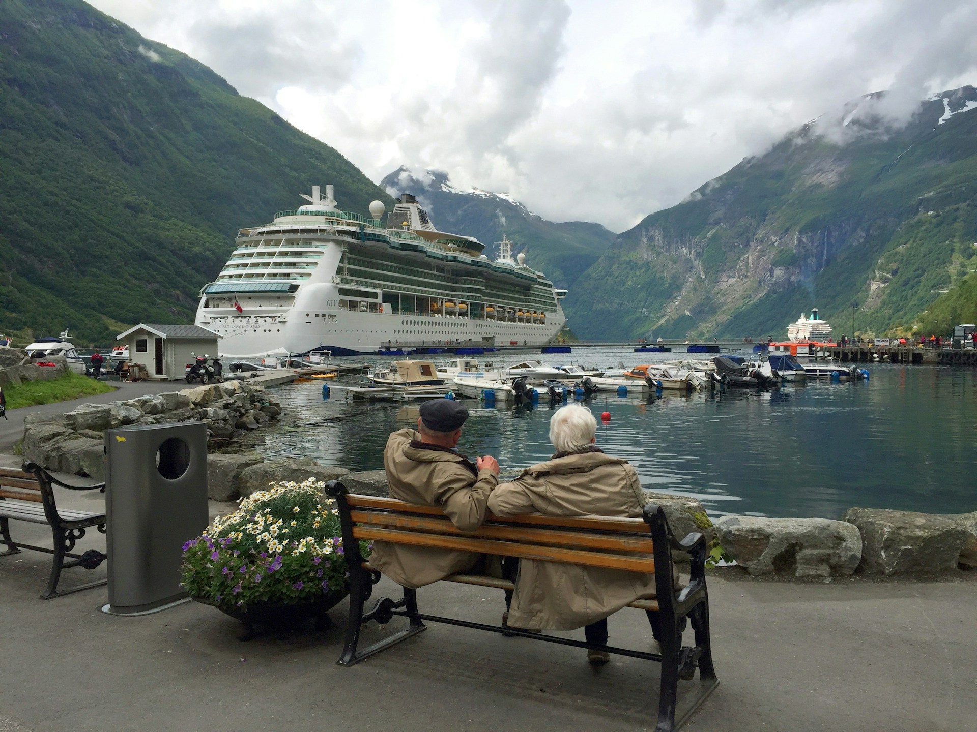 Una pareja de ancianos sentada en un banco mirando un crucero | Fuente: Unsplash