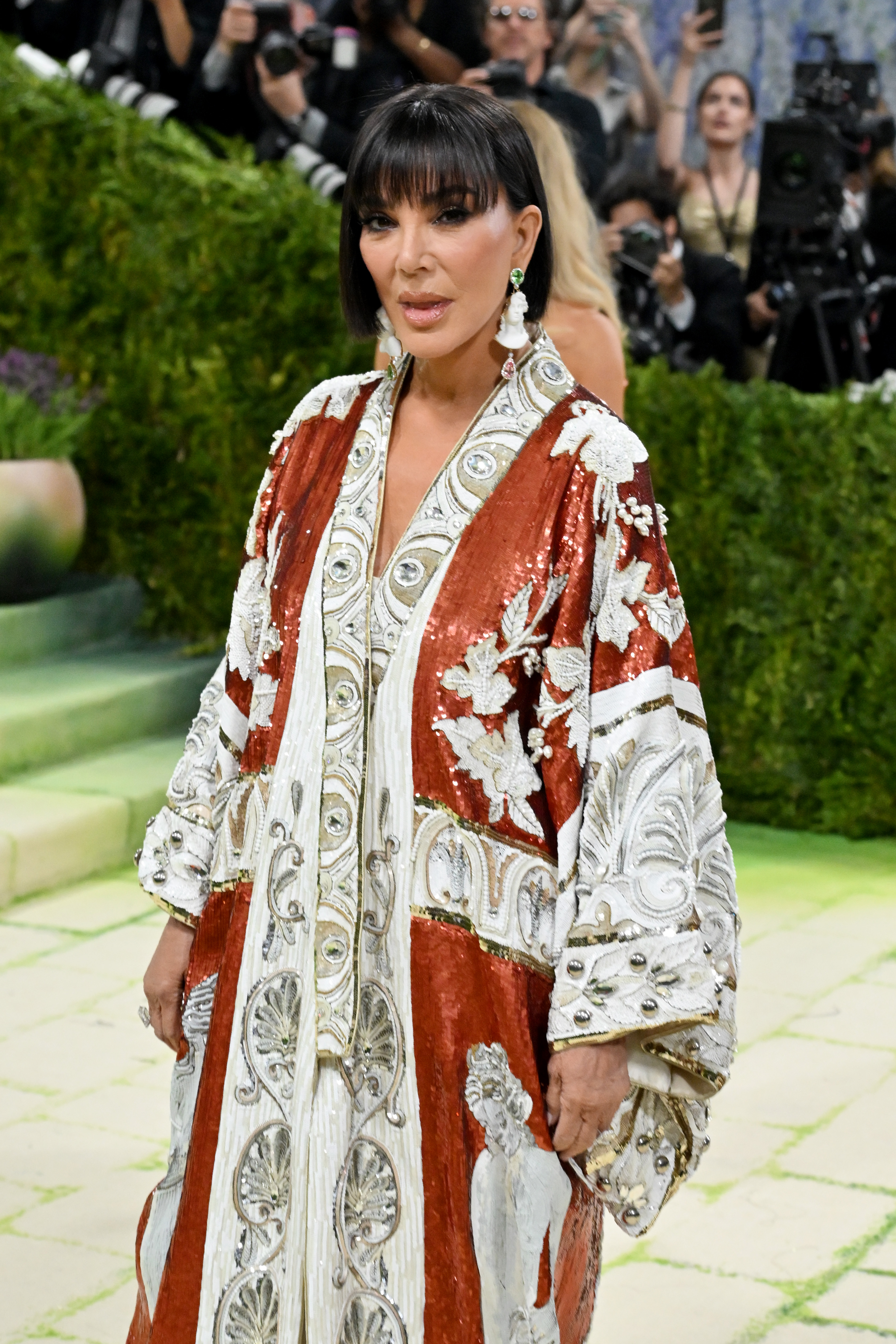Kris Jenner posa para los fotógrafos con su elegante conjunto rojo y blanco adornado en la Gala del Met. | Fuente: Getty Images