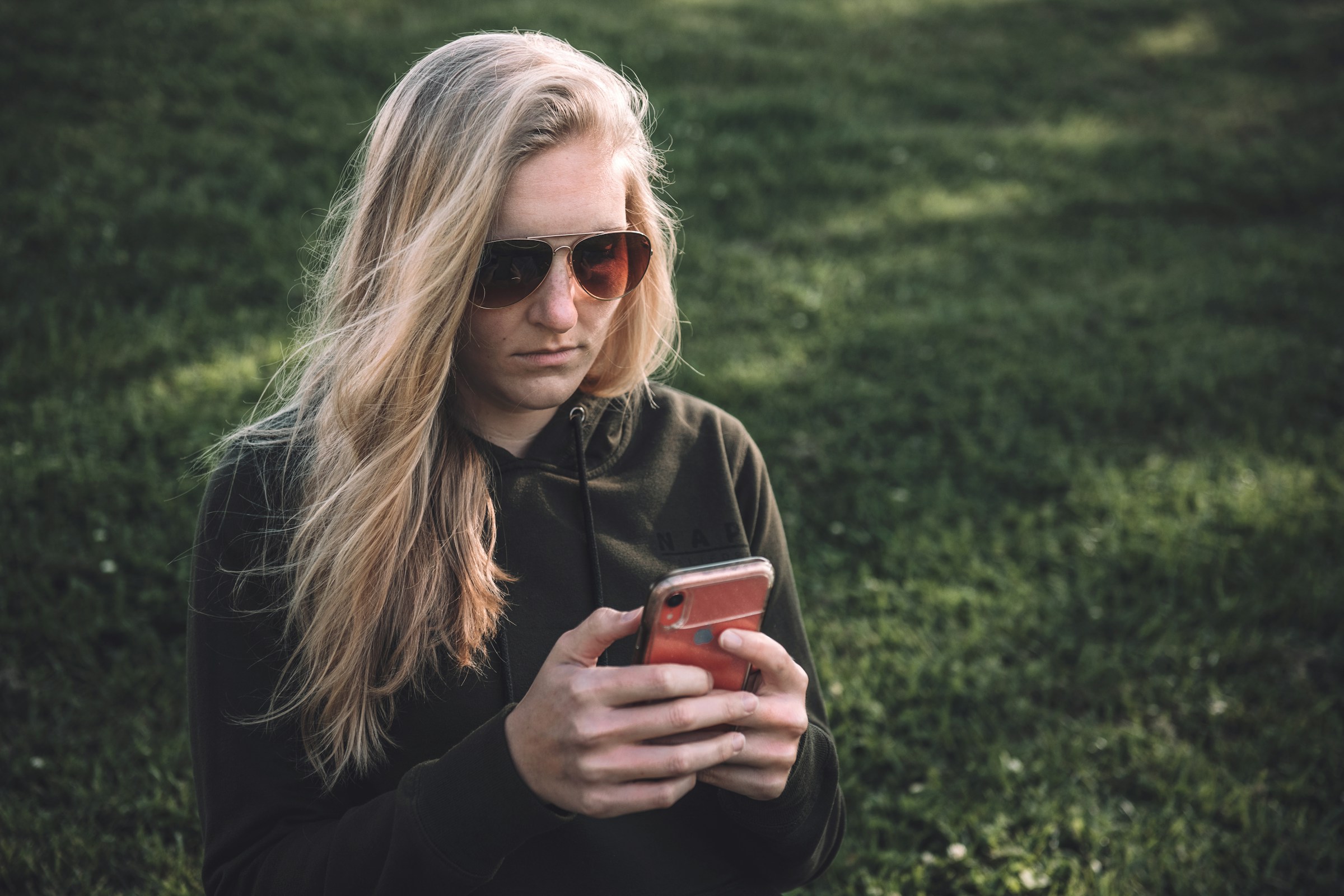 Una mujer frunce el ceño mientras envía mensajes de texto | Fuente: Unsplash