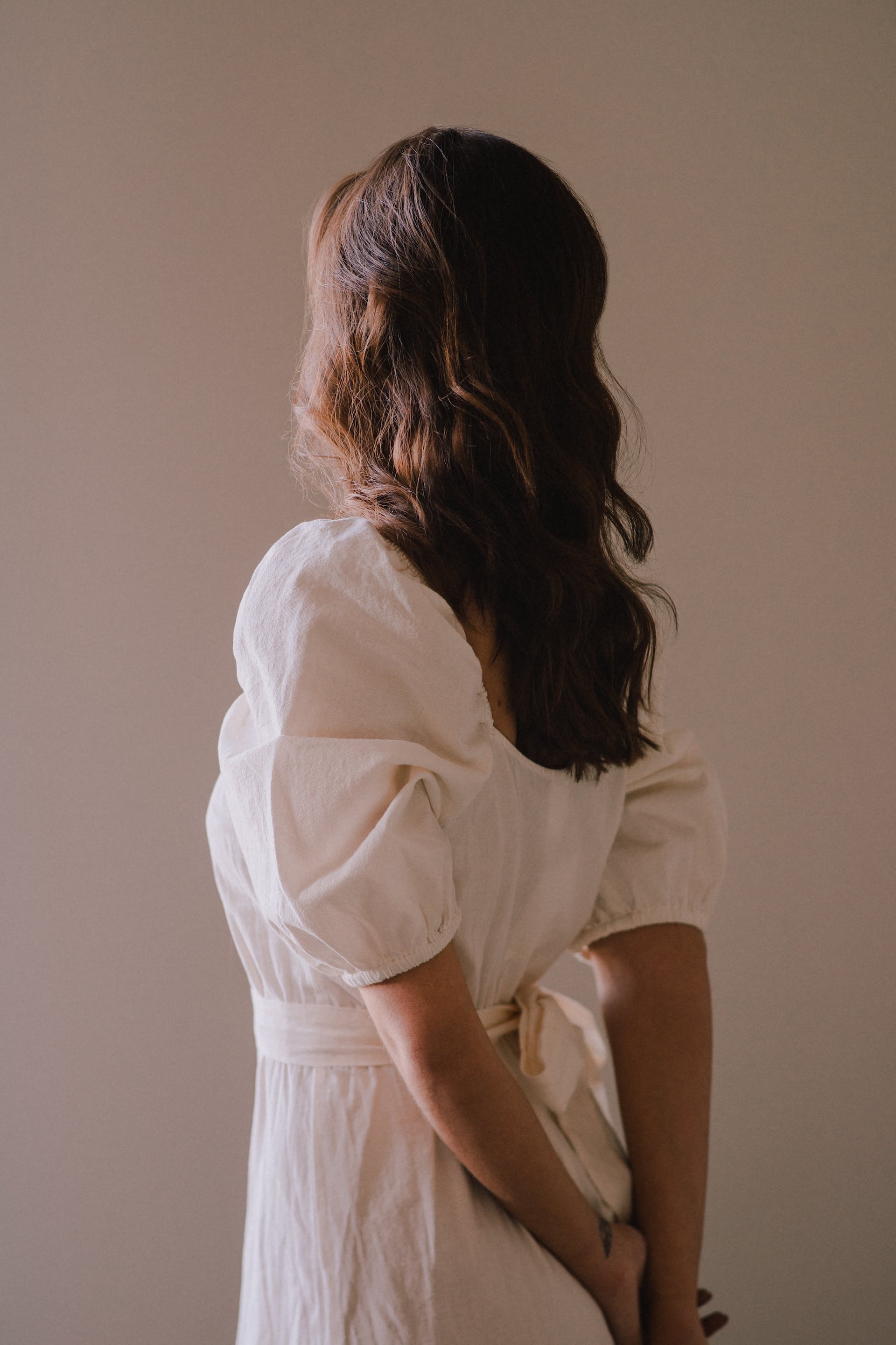 Mujer de pie con vestido blanco | Foto: Pexels