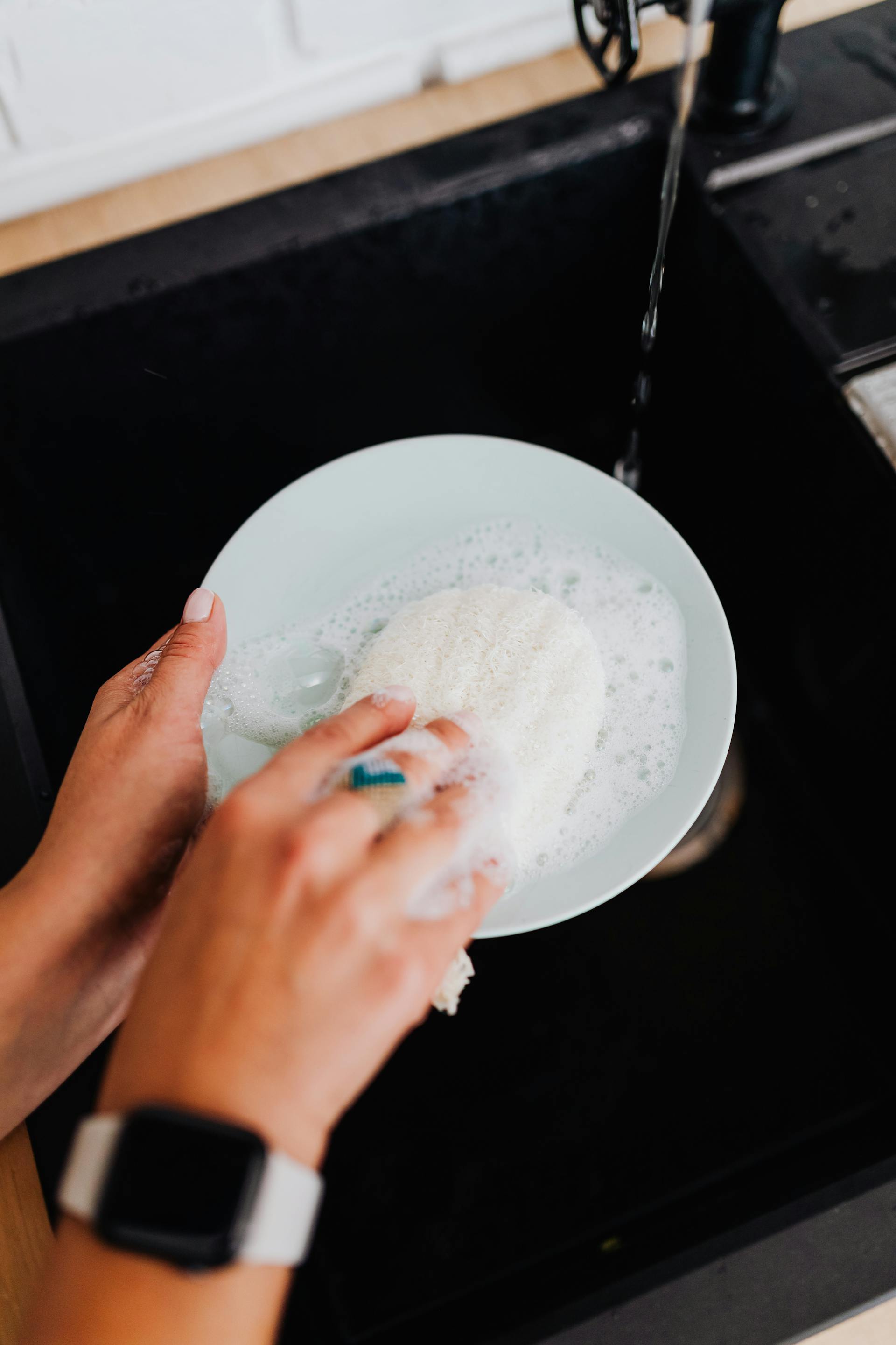 Una persona lavando platos | Fuente: Pexels