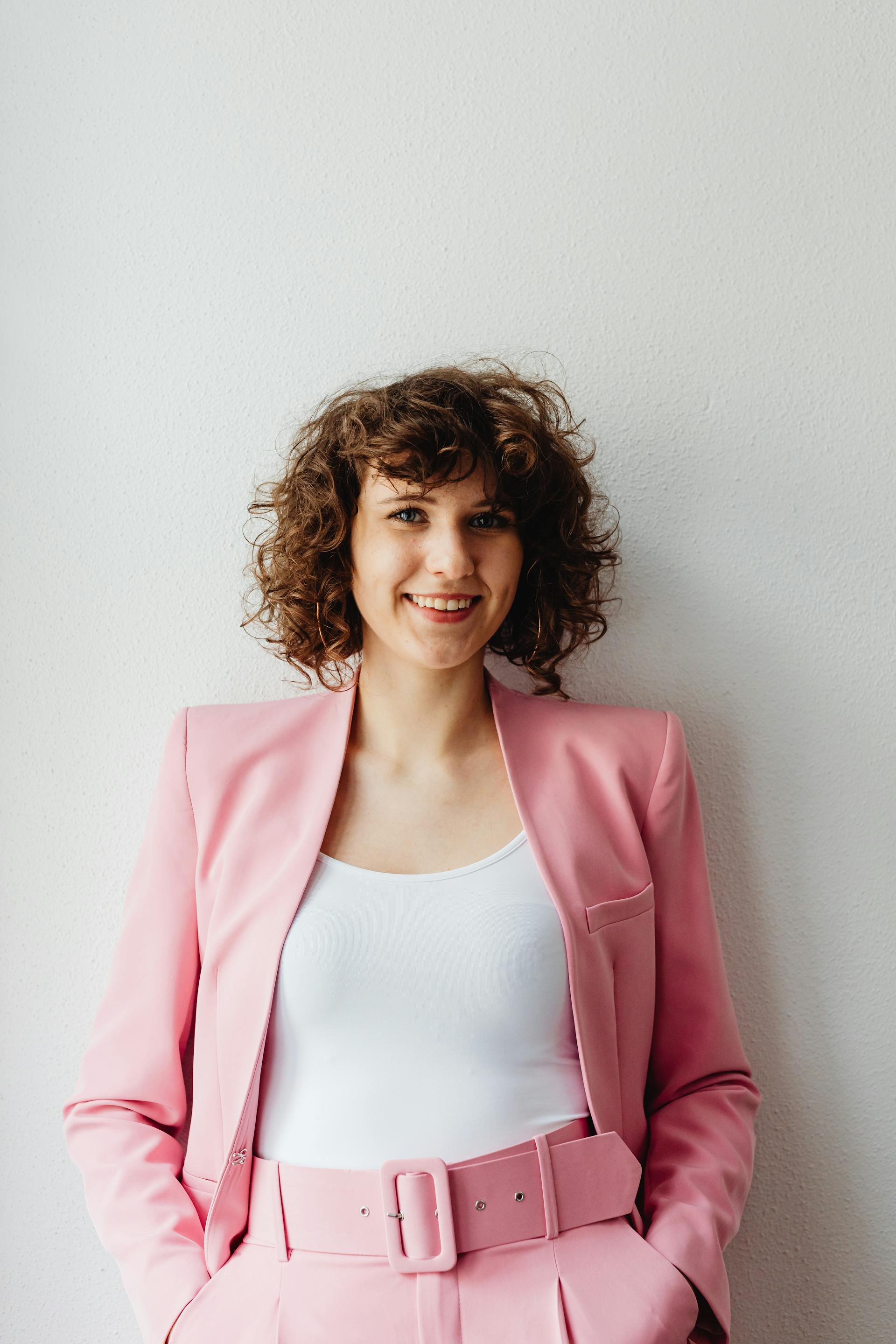 Una mujer de pie y sonriendo | Fuente: Pexels