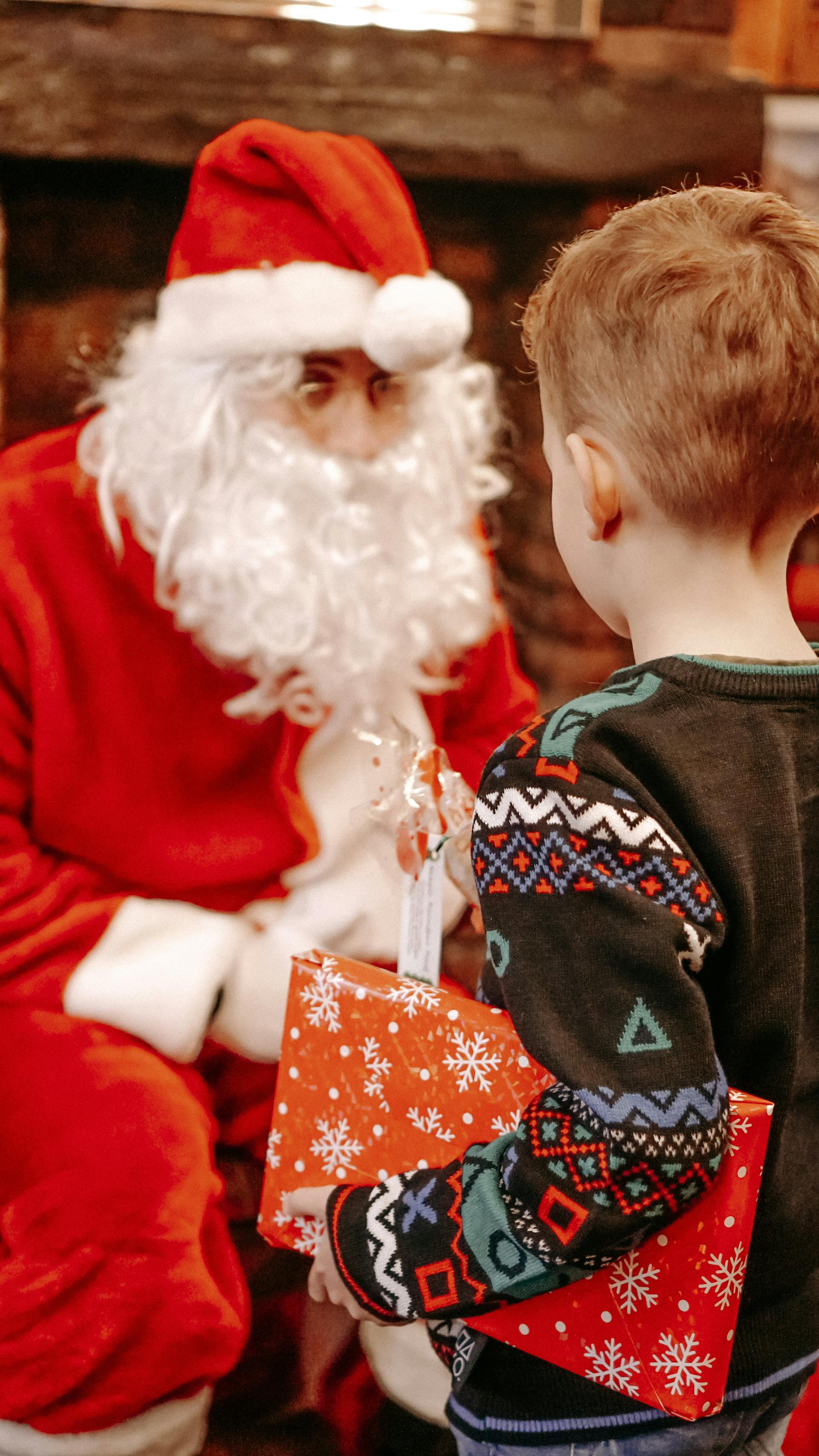 Un niño recibe un regalo de Papá Noel en Navidad | Fuente: Pexels