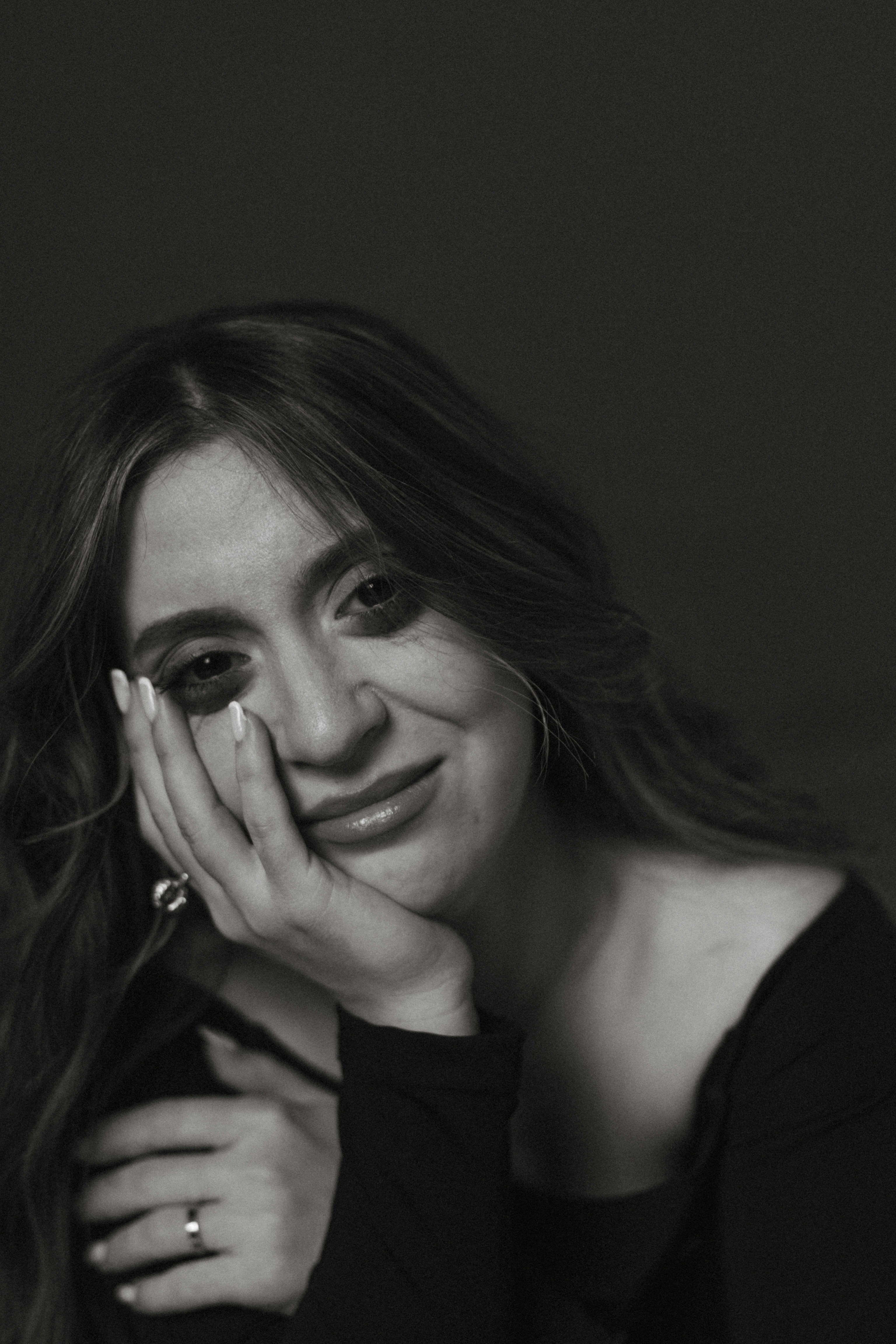 Primer plano de una mujer sonriendo tristemente | Fuente: Unsplash