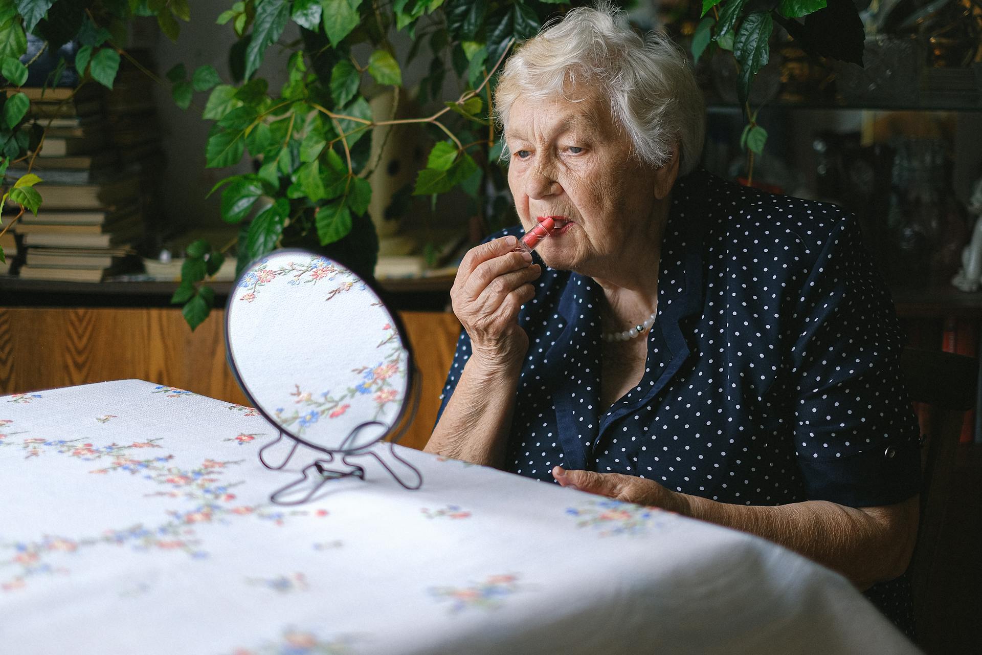 Una anciana aplicándose pintalabios | Fuente: Pexels