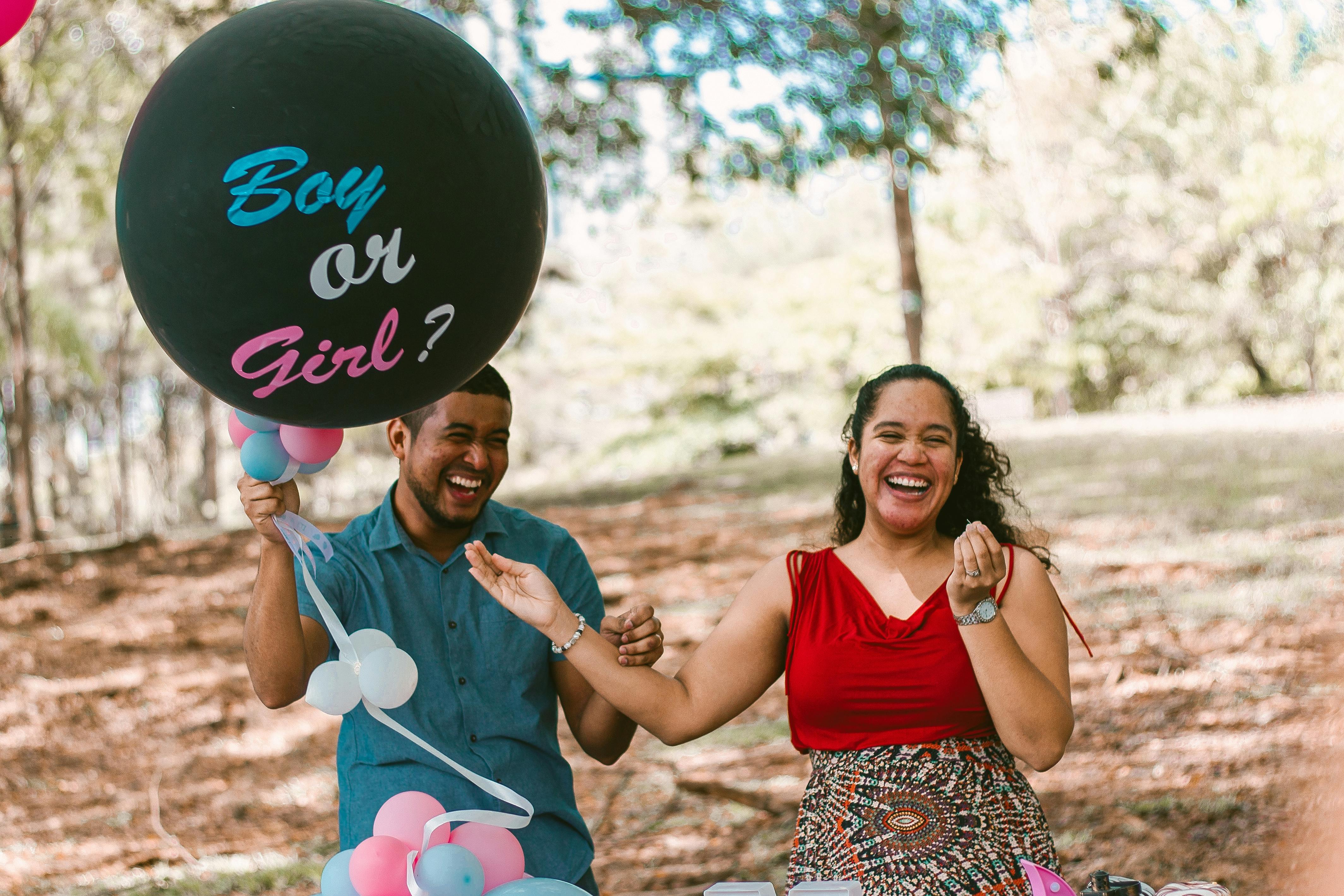 Un hombre y una mujer embarazada riendo en una fiesta de revelación de sexo | Fuente: Pexels