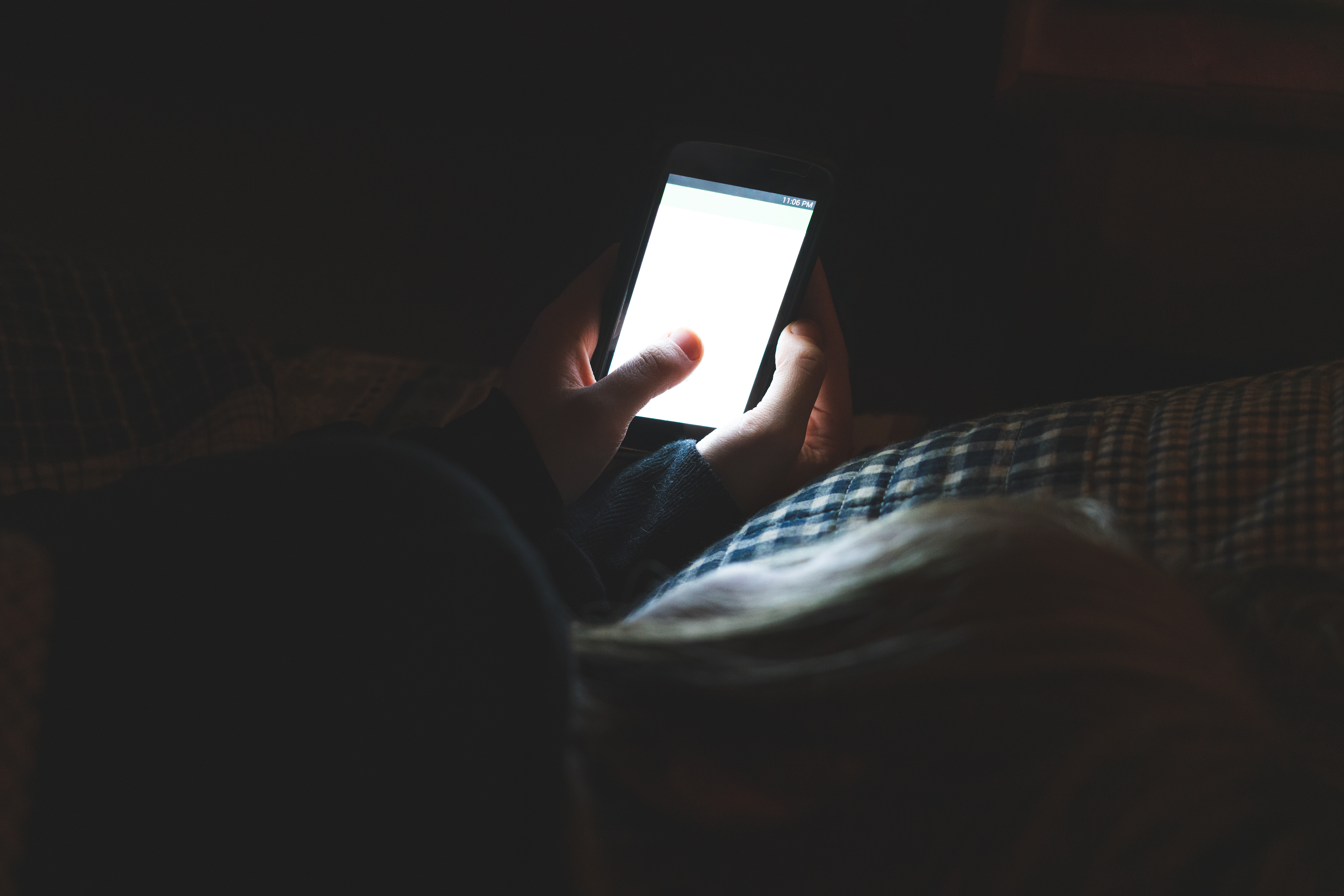 Persona con un teléfono en la oscuridad | Foto: Shutterstock