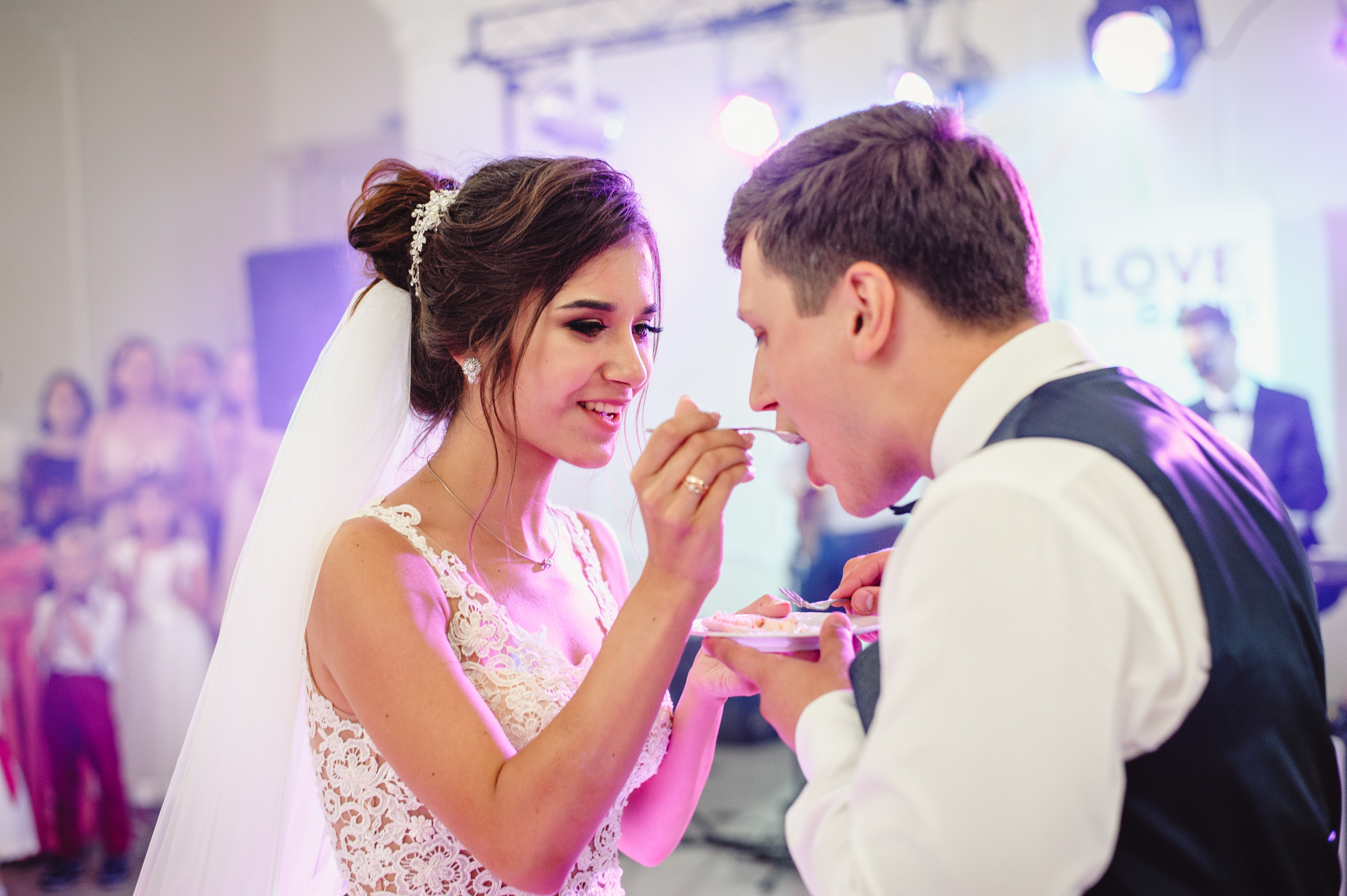 Una novia dando de comer un trozo de pastel a su novio | Fuente: Shutterstock