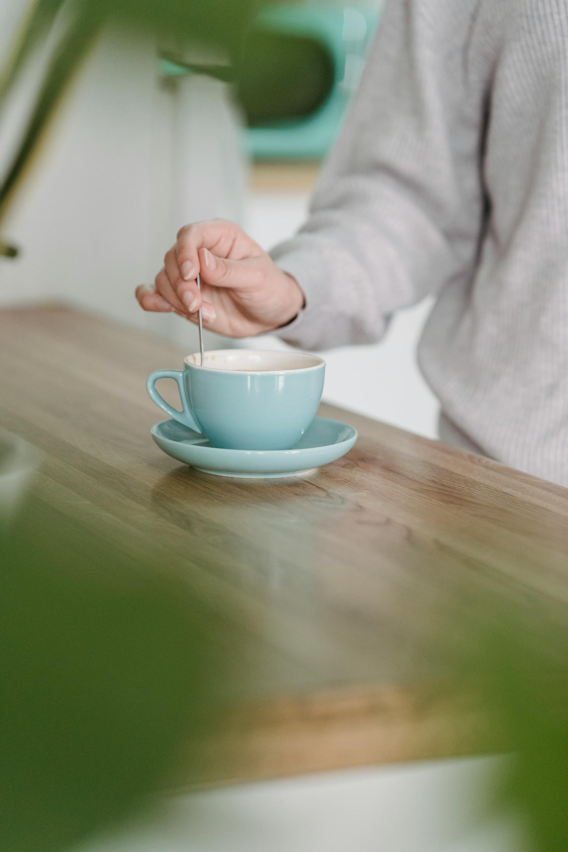 Primer plano de una mujer removiendo su taza de café en la cocina | Fuente: Pexels