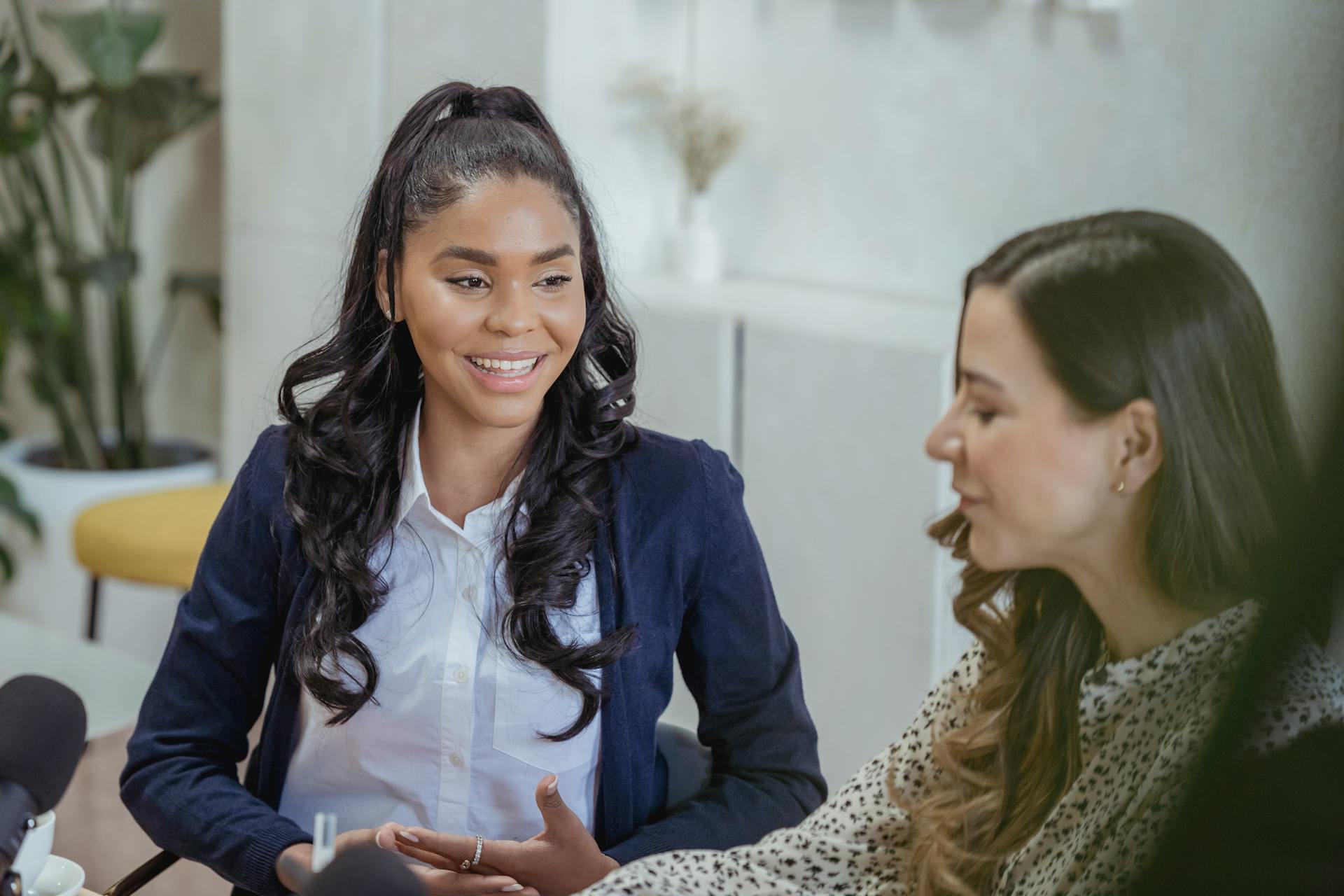 Dos mujeres hablando mientras las graban con un micrófono | Fuente: Pexels