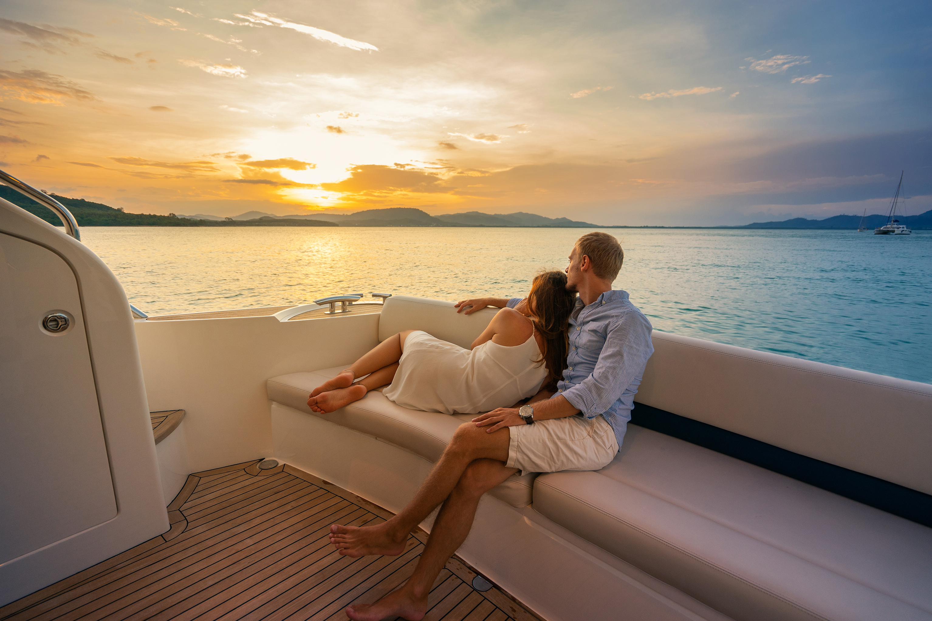 Vacaciones románticas . Hermosa pareja mirando la puesta de sol desde el yate. | Fuente: Shutterstock