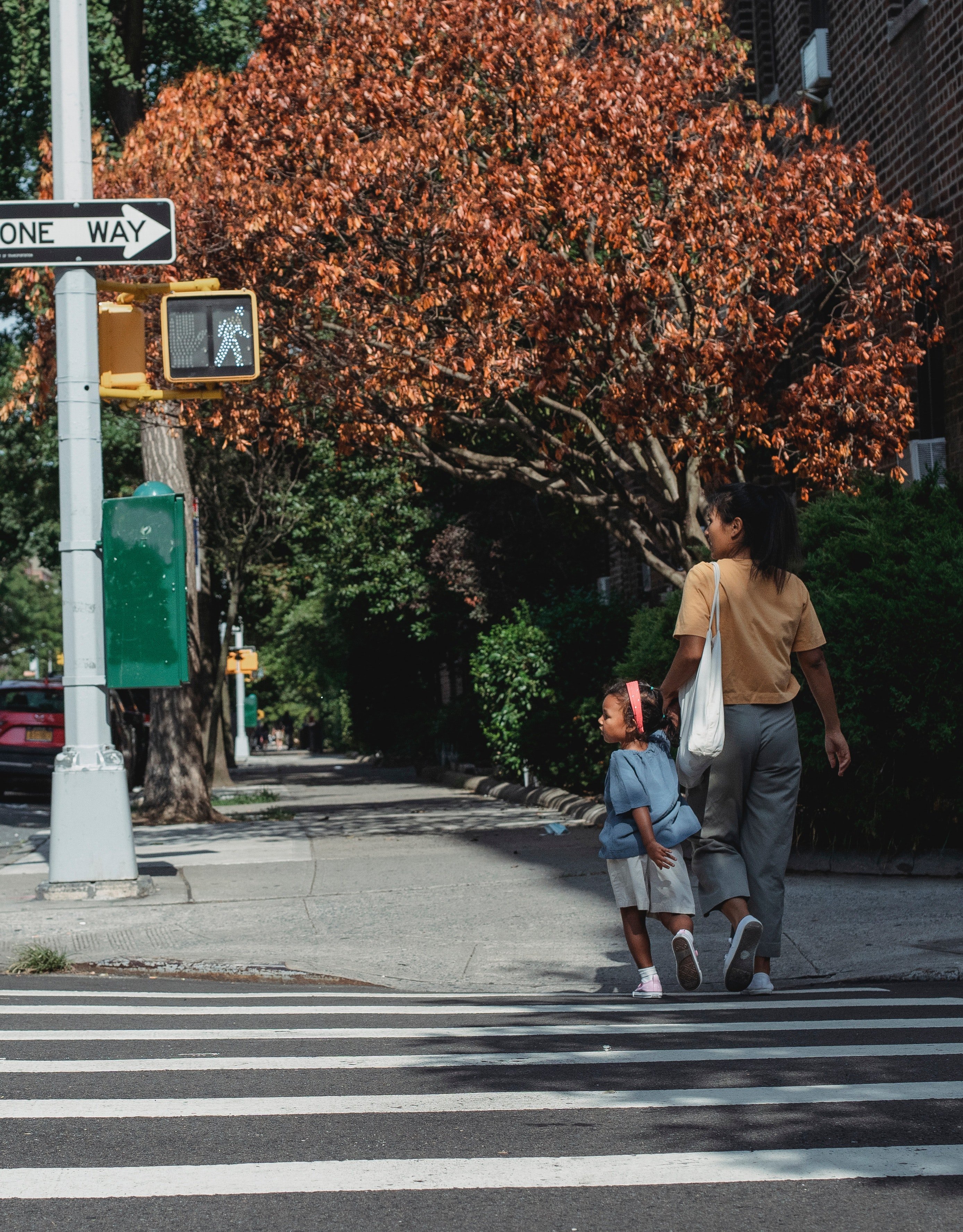 Una mujer y su hija caminando por un paso peatonal. | Foto: Pexels