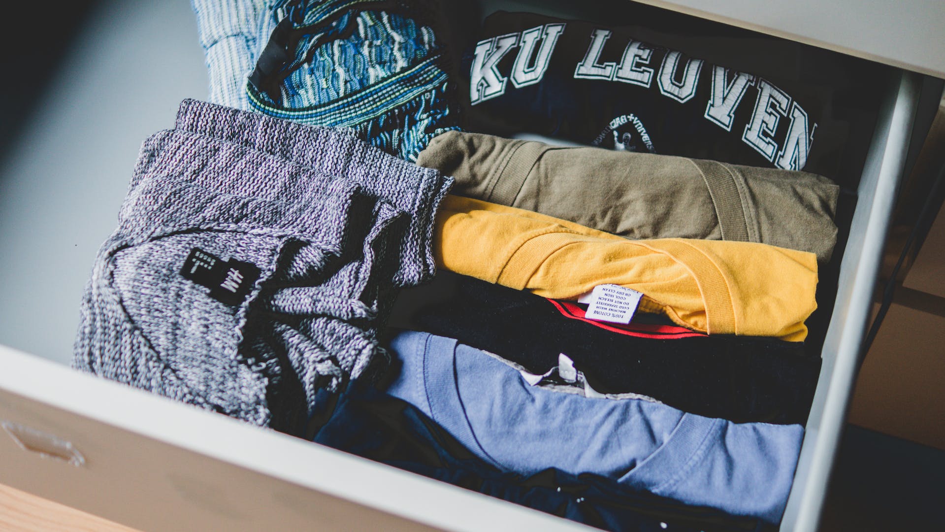 Camisas de colores dobladas colocadas en un cajón | Foto: Pexels