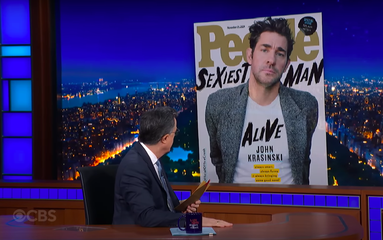 Stephen Colbert mirando la foto de portada de la revista People de John Krasinski durante un episodio de "The Late Show with Stephen Colbert", publicado el 13 de noviembre de 2024 | Fuente: YouTube/The Late Show with Stephen Colbert