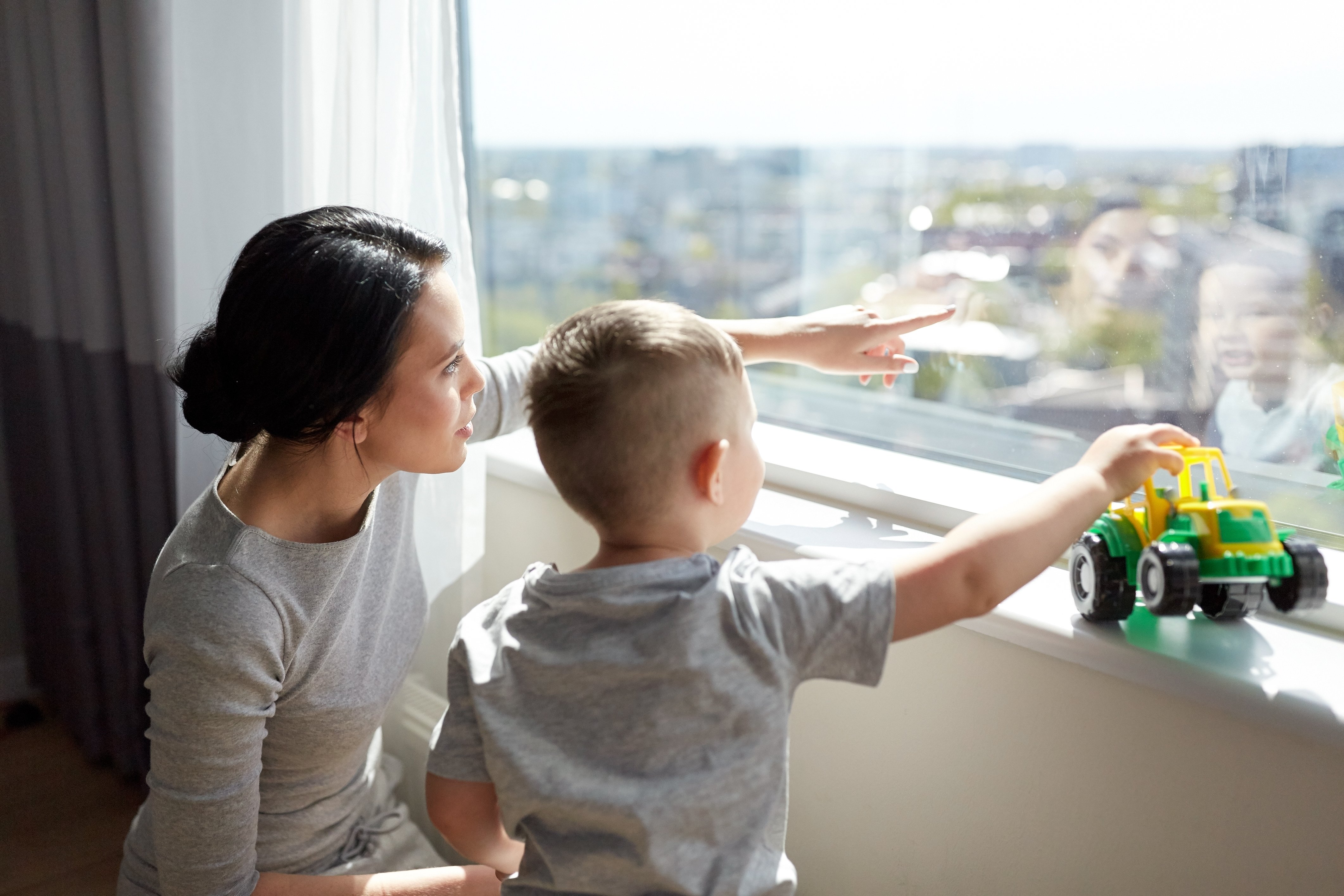 Madre e hijo viendo por la ventana de un hotel. | Foto: Shutterstock