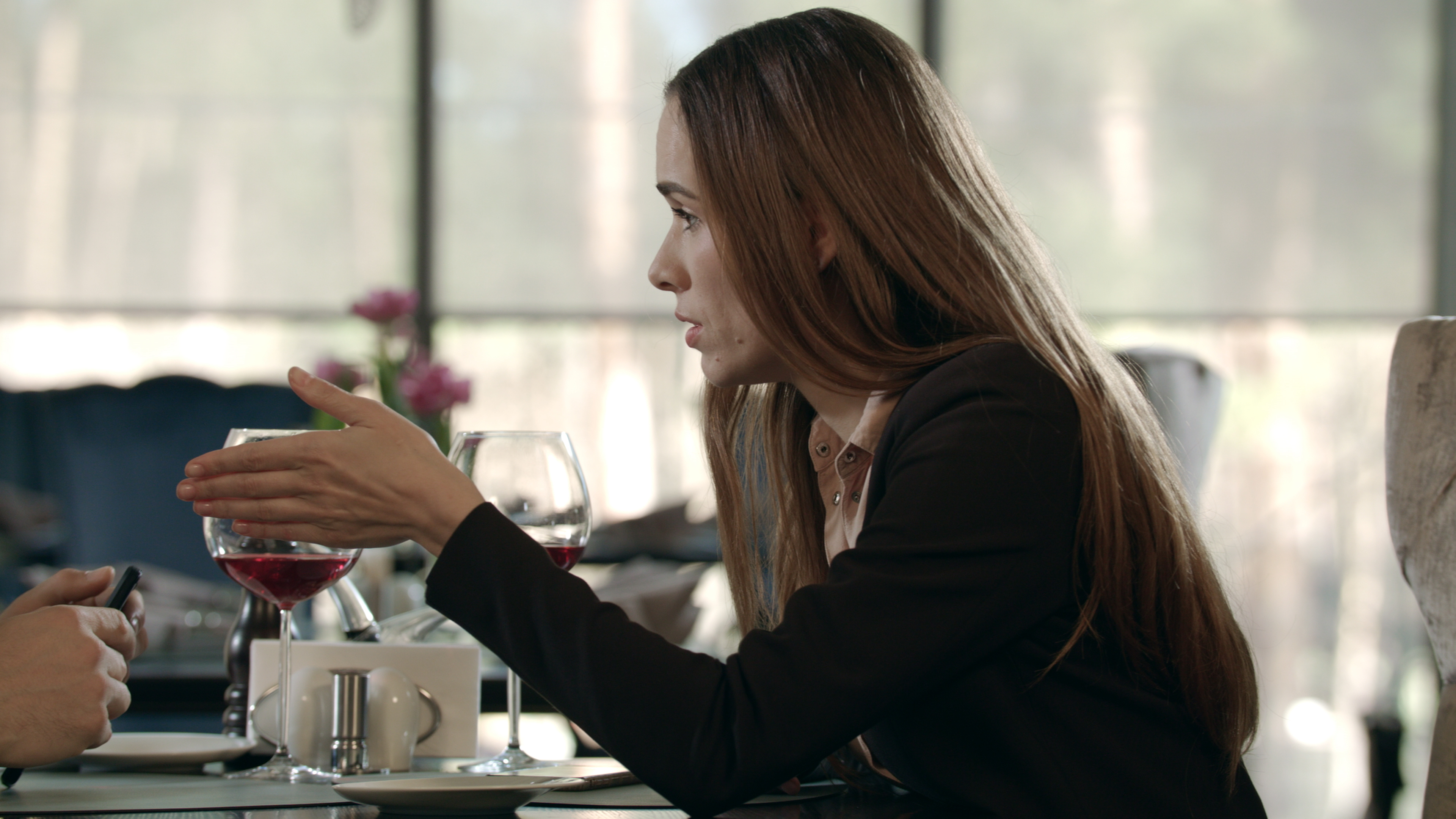 Mujer seria hablando con un hombre en la mesa de un restaurante. | Fuente: Shutterstock