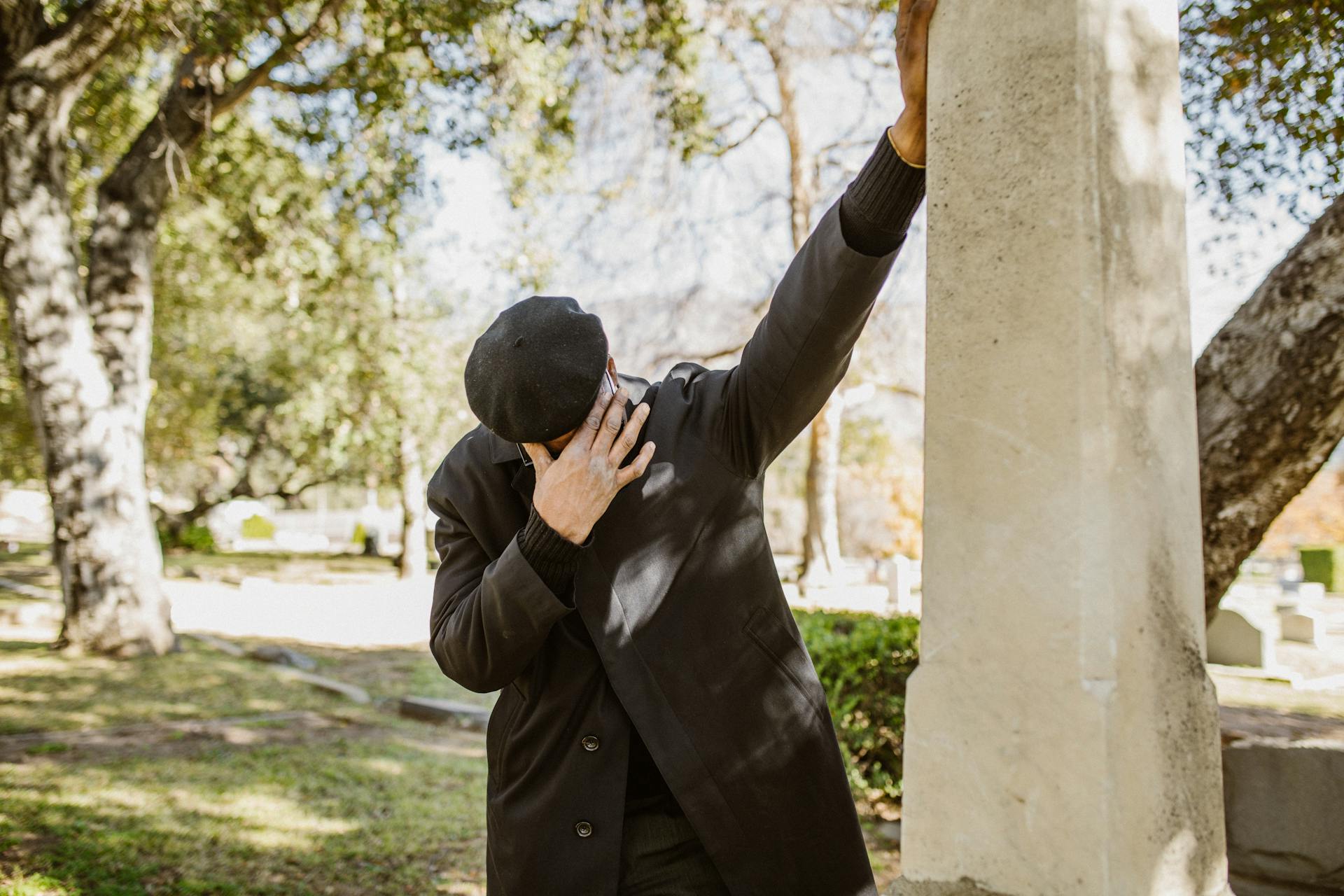 Primer plano de un hombre con traje negro llorando en un cementerio | Fuente: Pexels