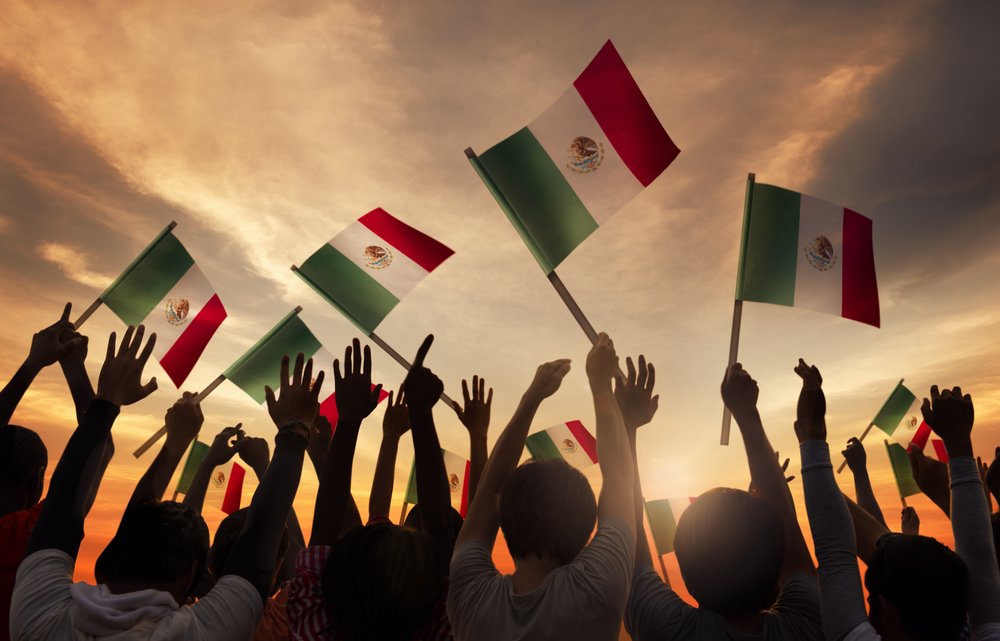 Grupo de personas con banderas mexicanas.| Fuente: Shutterstock