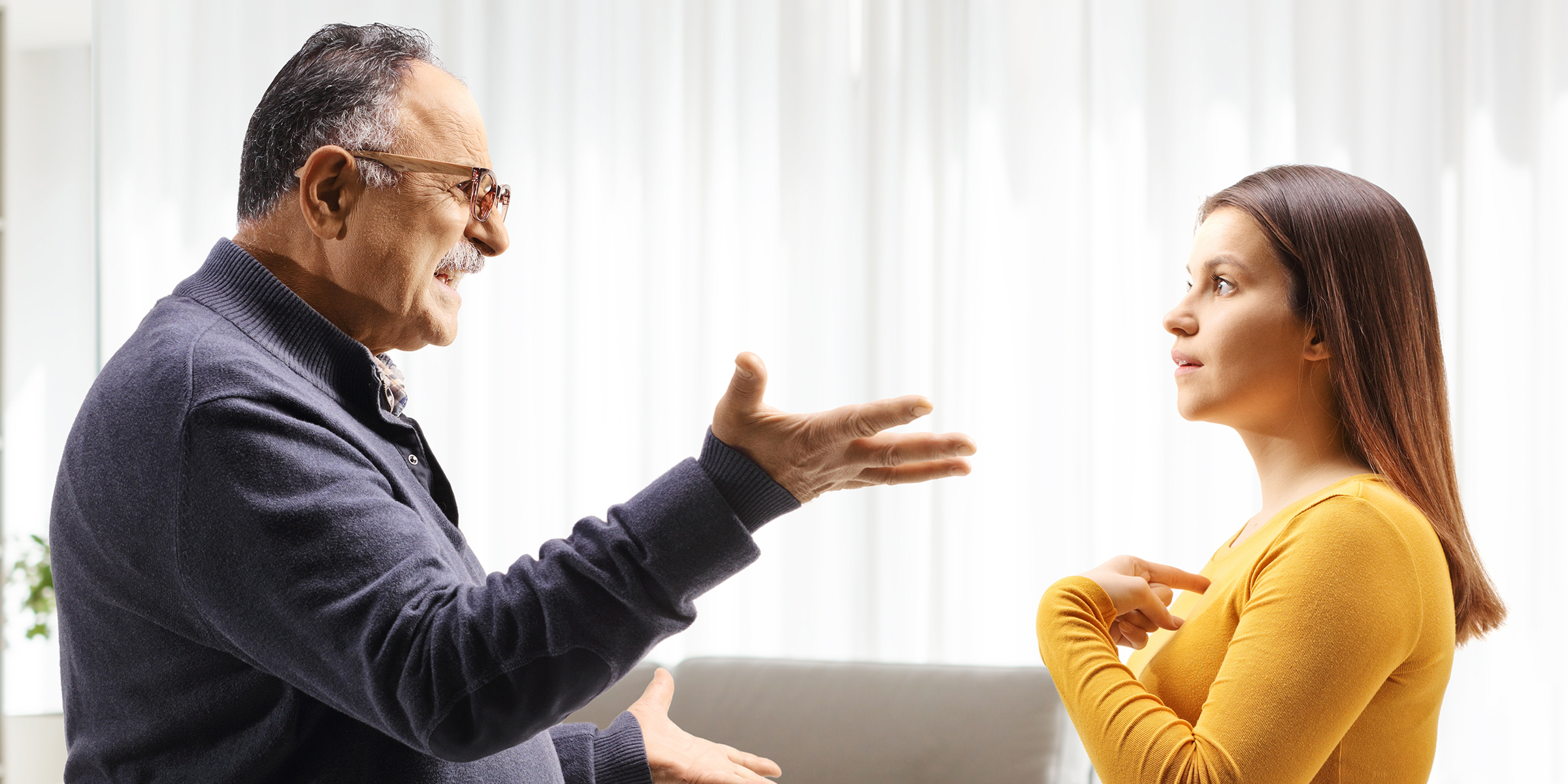 Hombre enfadado discutiendo con una joven | Fuente: Shutterstock