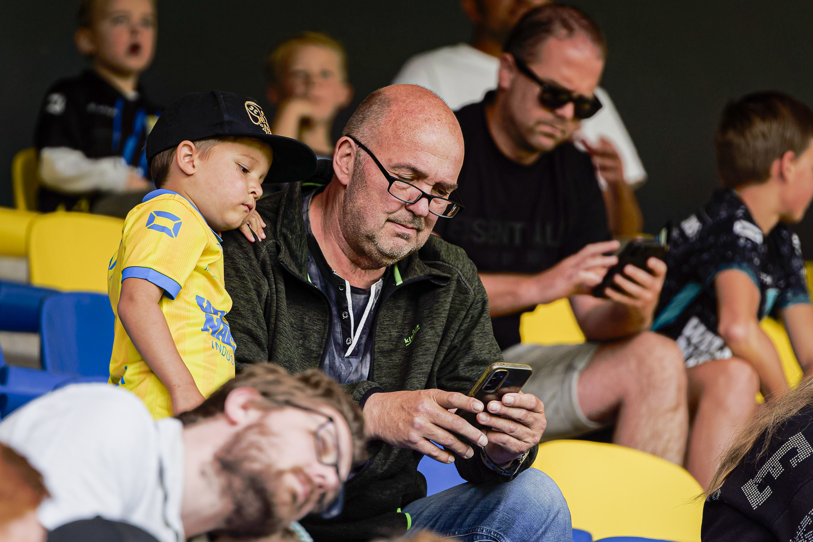 Papá mirando un teléfono con su hijo | Fuente: Getty Images