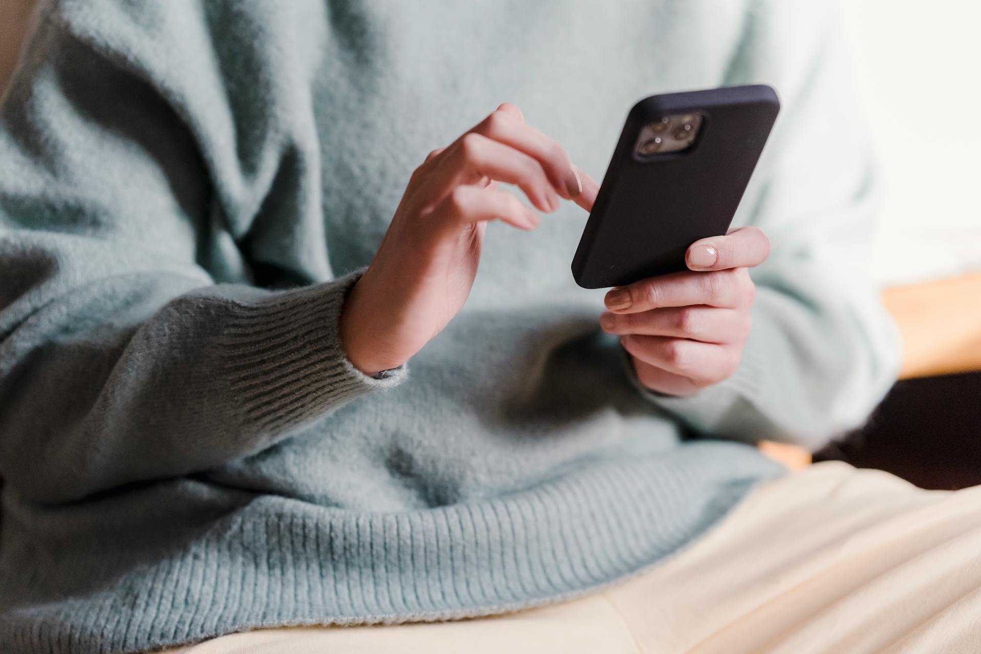 Una mujer haciendo scroll en su teléfono | Fuente: Midjourney