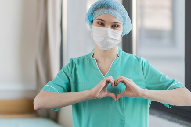 Enfermera dando una señal de amor. │Foto: Freepik