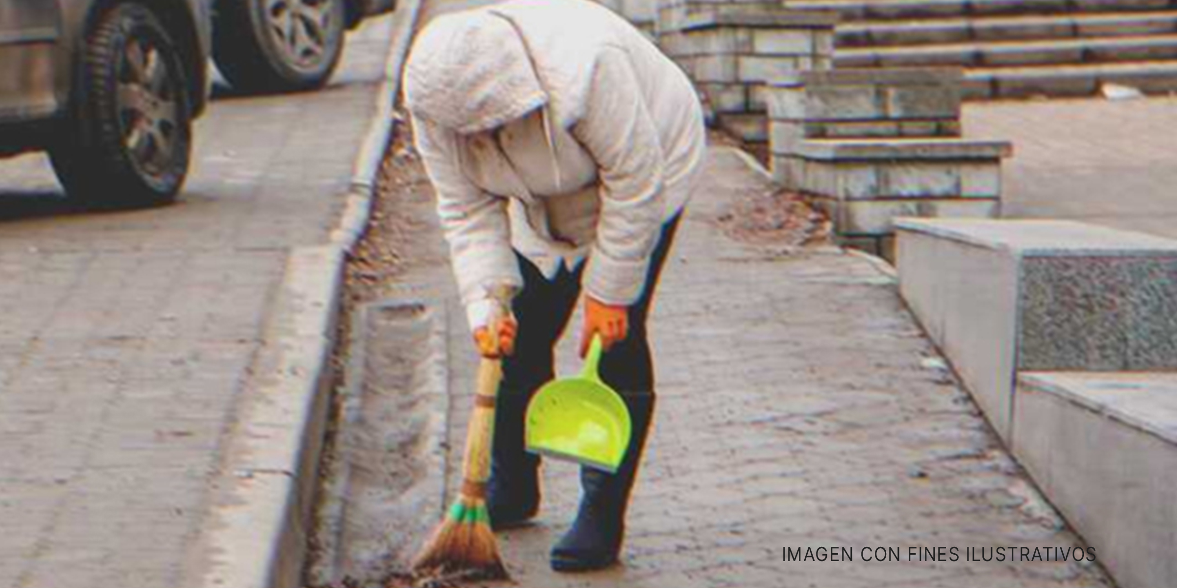 Mujer barriendo una acera. | Foto: Shutterstock
