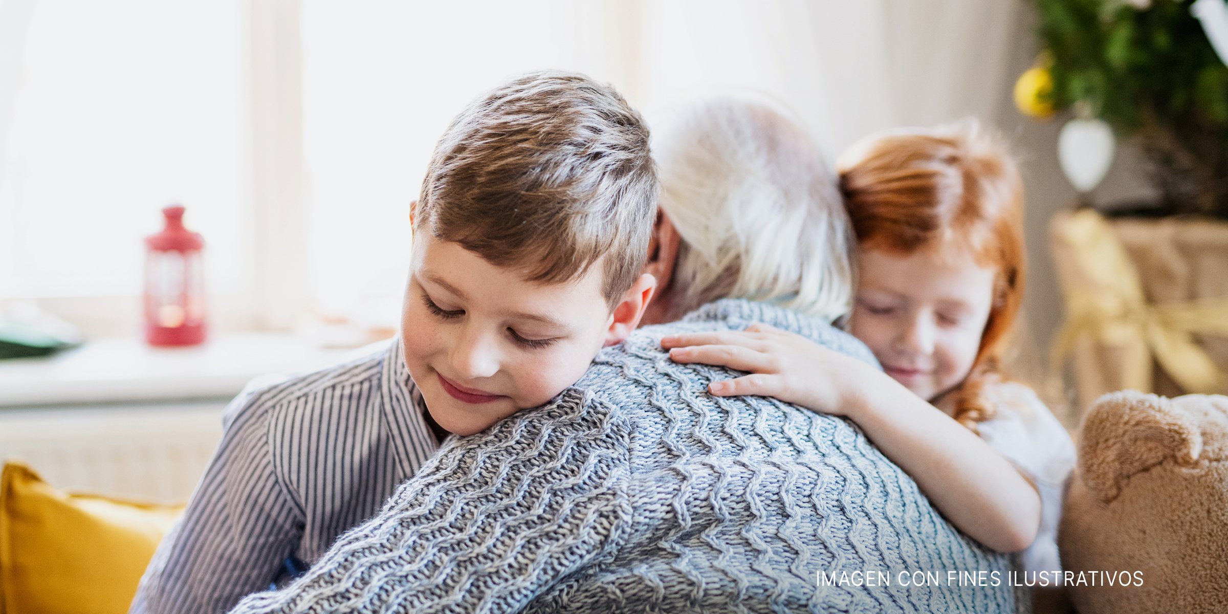 Niños abrazando a un hombre mayor | Foto: Shutterstock