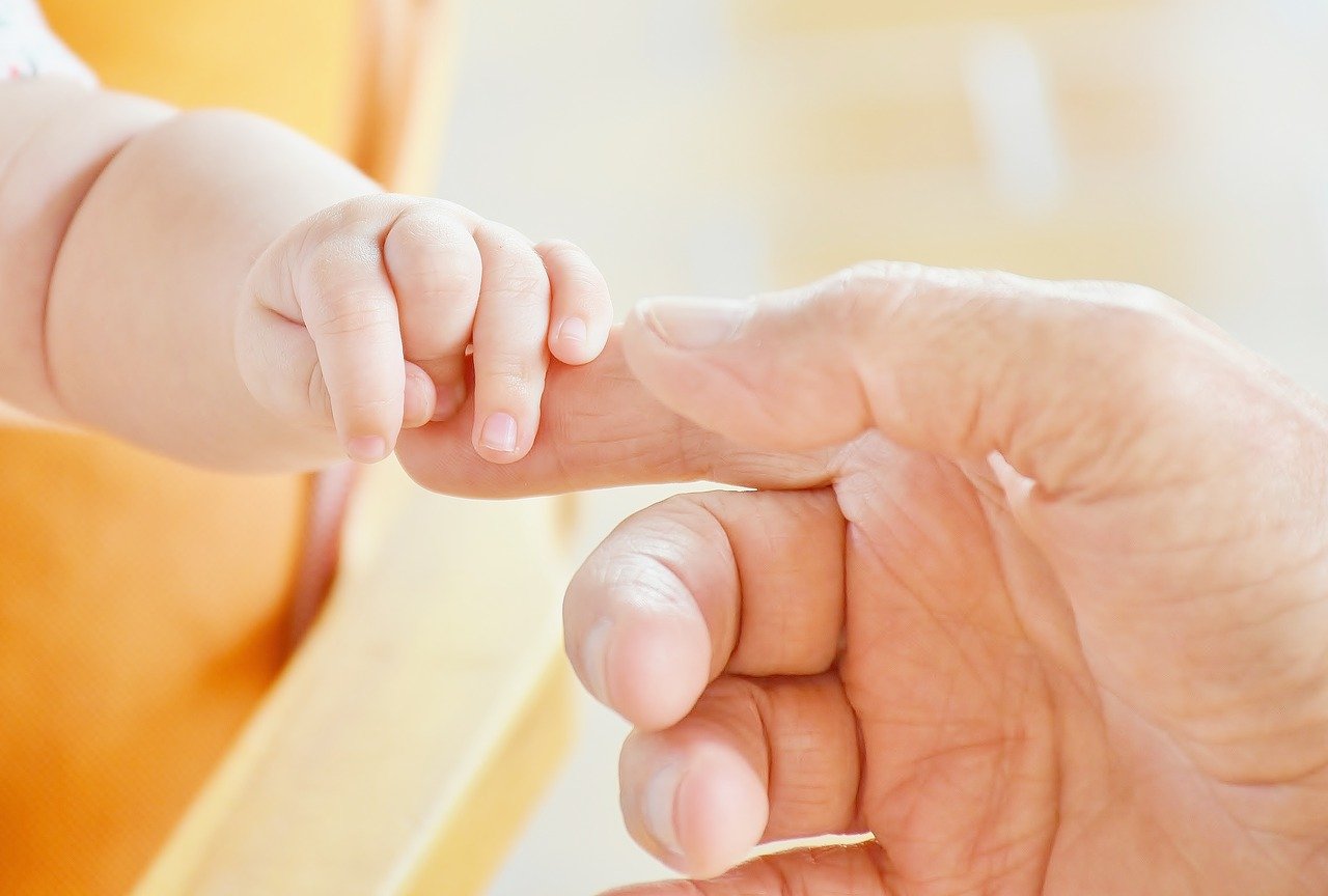 Bebé agarra el dedo de su padre.| Foto: Pixabay