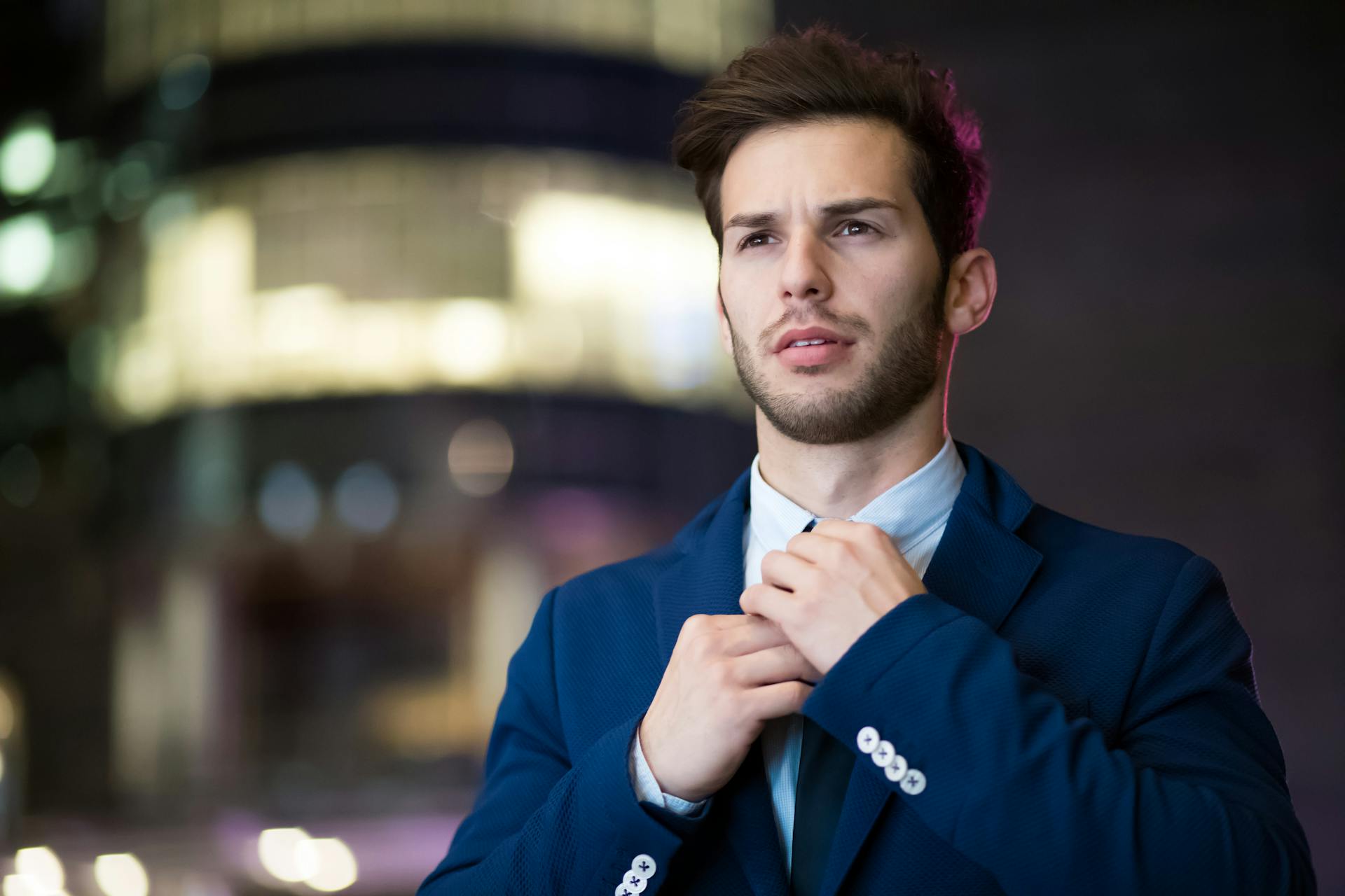 Un hombre guapo ajustándose la corbata | Fuente: Pexels